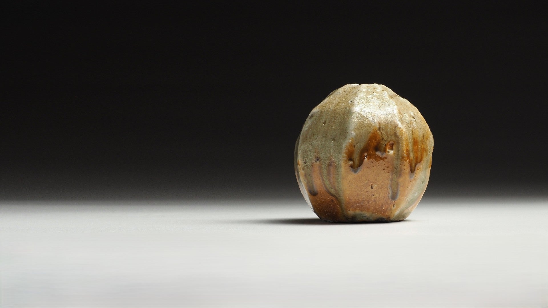 Anagama fired yakishime flower vase from Shigaraki on a faded background.