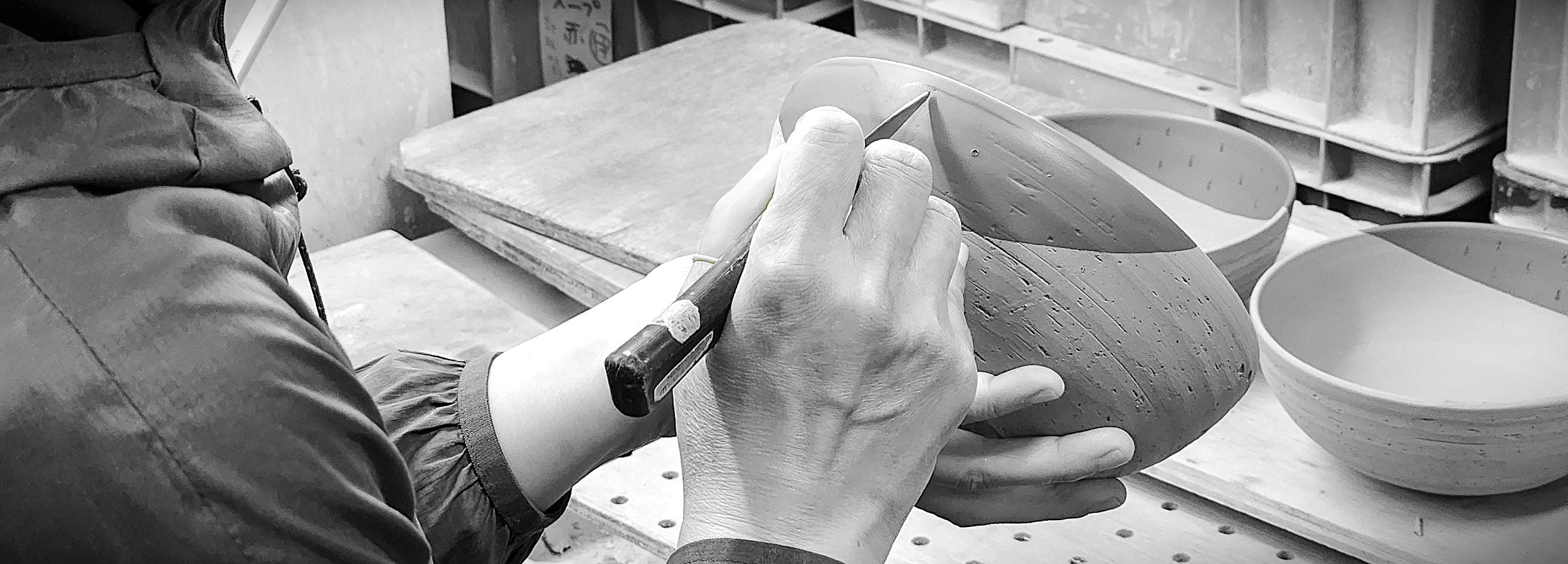 A Japanese pottery bowl being carved by expert hands.