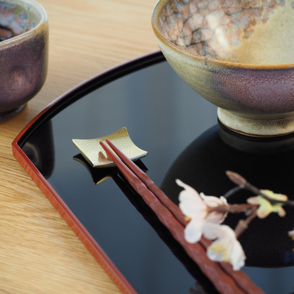 gold hashioki on black tray and sakura
