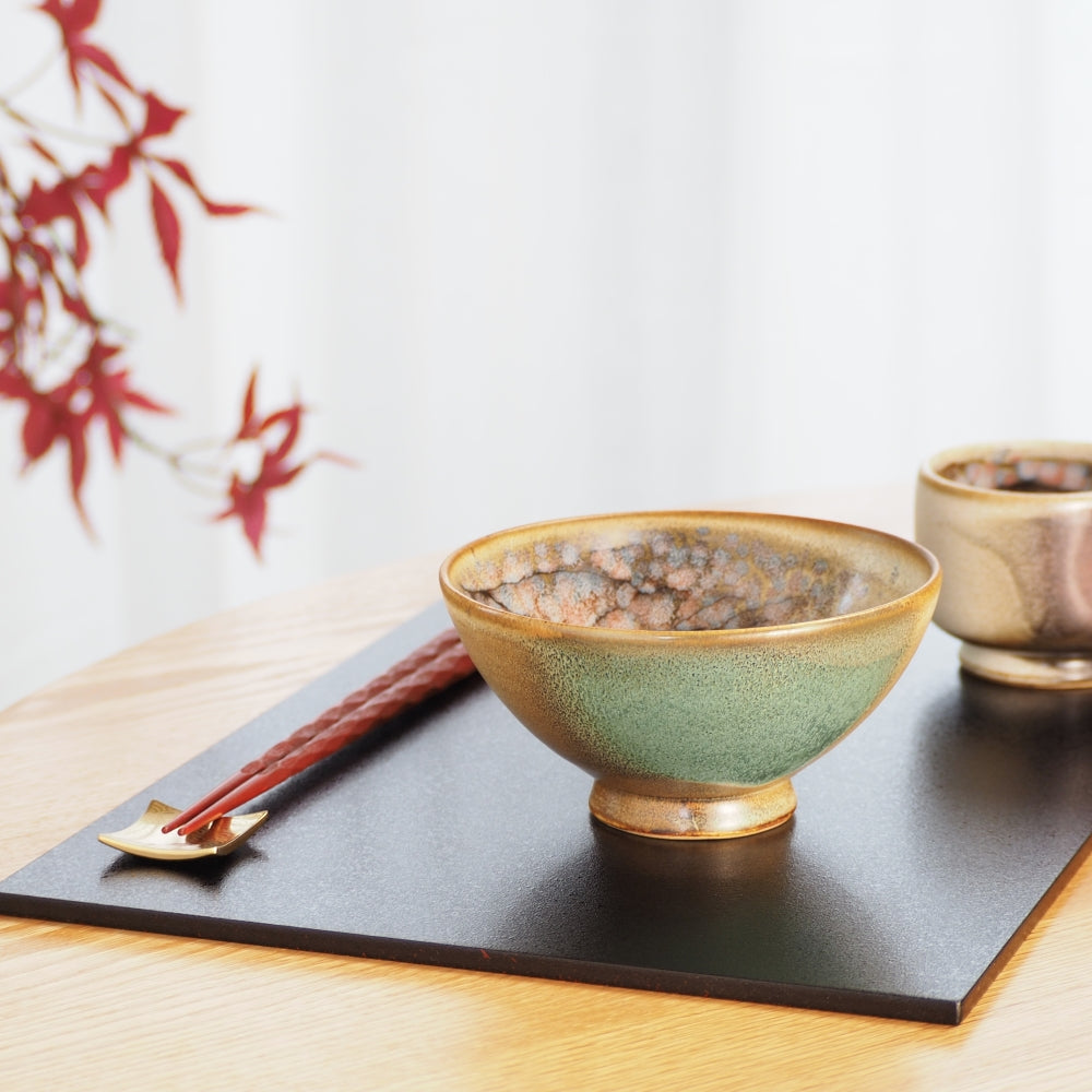 A handcrafted Japanese ceramic bowl and teacup on a black tray with red leaf. Tsukushi