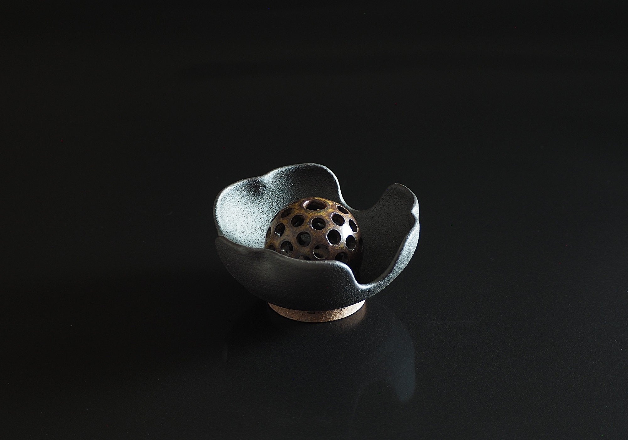Handcrafted Japanese dark brown ceramic flower frog with decorative elements on a black background, Tsukushi