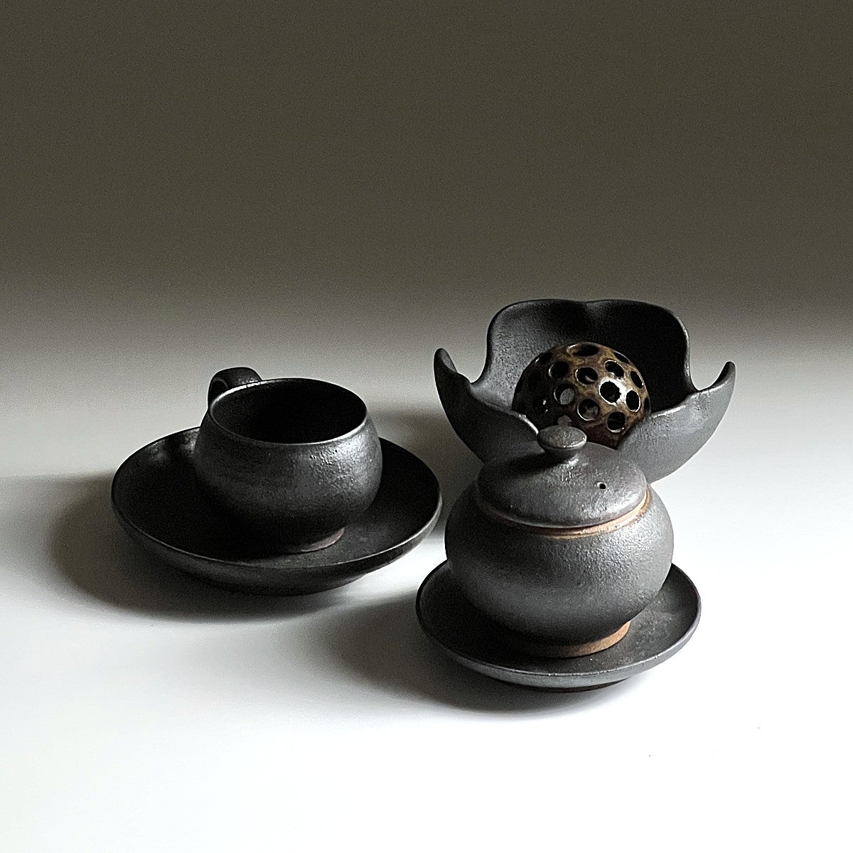 Bird’s-eye view of three Japanese pottery pieces including a coffee cup, an ikebana vase and a chawanmushi bowl. Tsukushi.