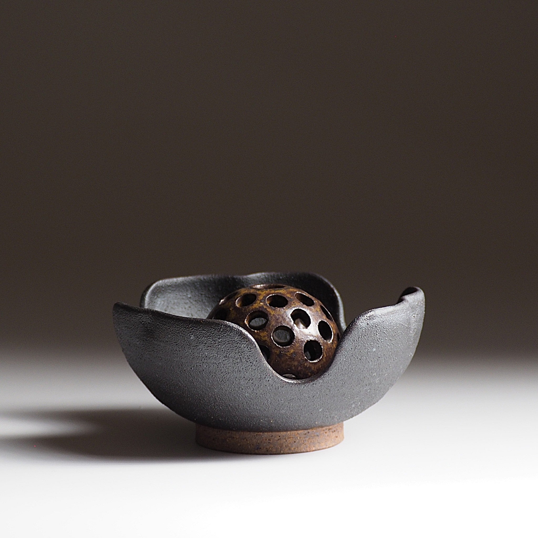 Japanese ikebana vase with ceramic flower frog an matching bowl on a faded background. Tsukushi