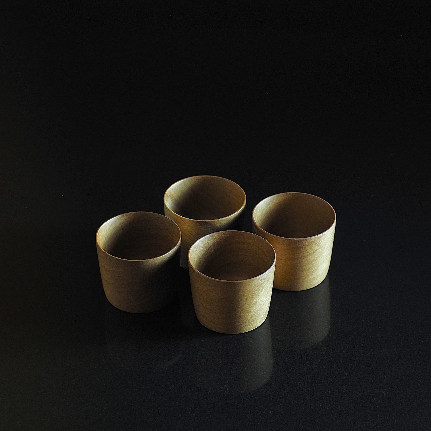 Japanese wooden sake cup set on a black background. Tsukushi