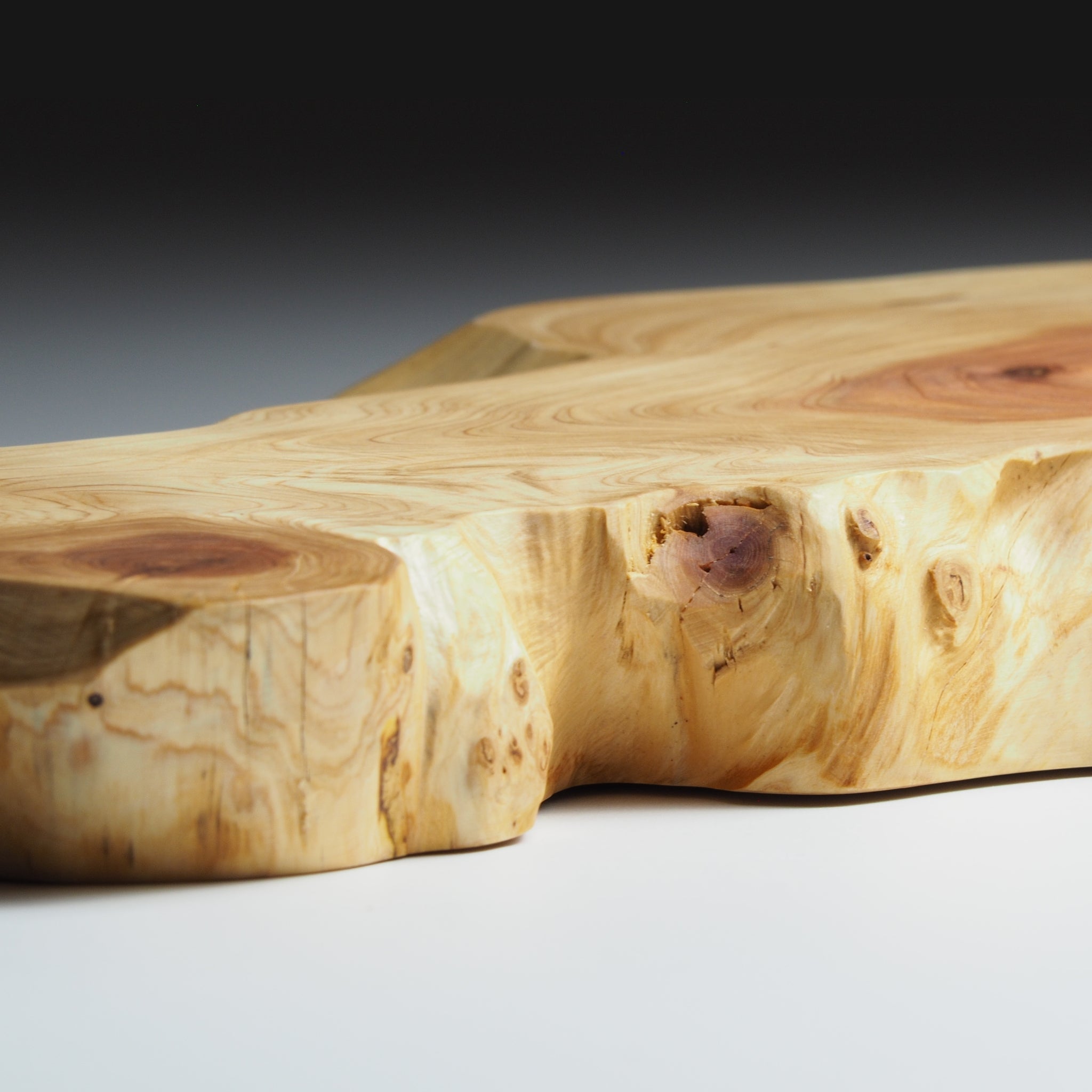 Close-up of a Japanese wooden sushi tray on a light gray background. Tsukushi