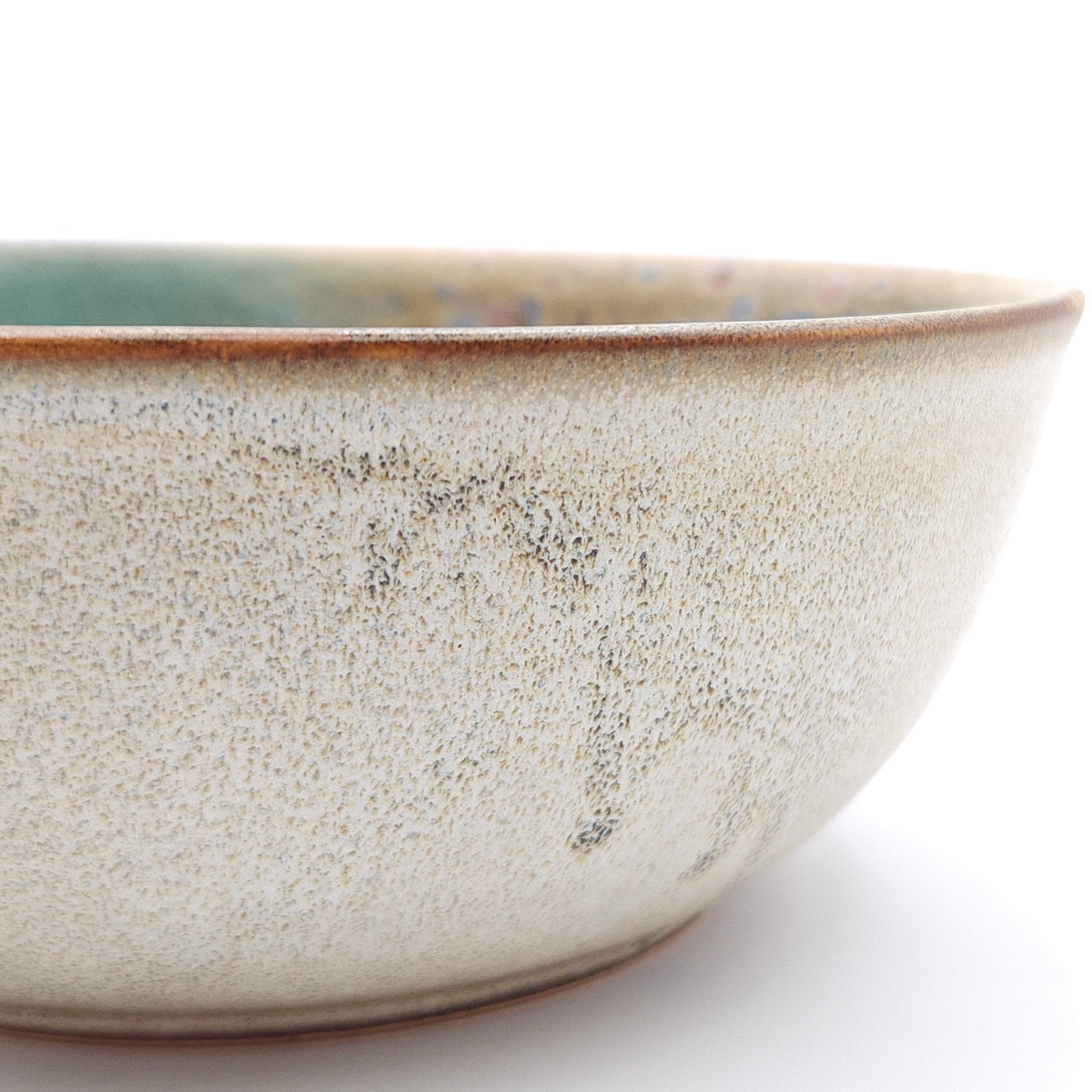 Authentic Japanese pottery salad bowl with cherry blossoms decoration. green and beige color. (side detail view 1).