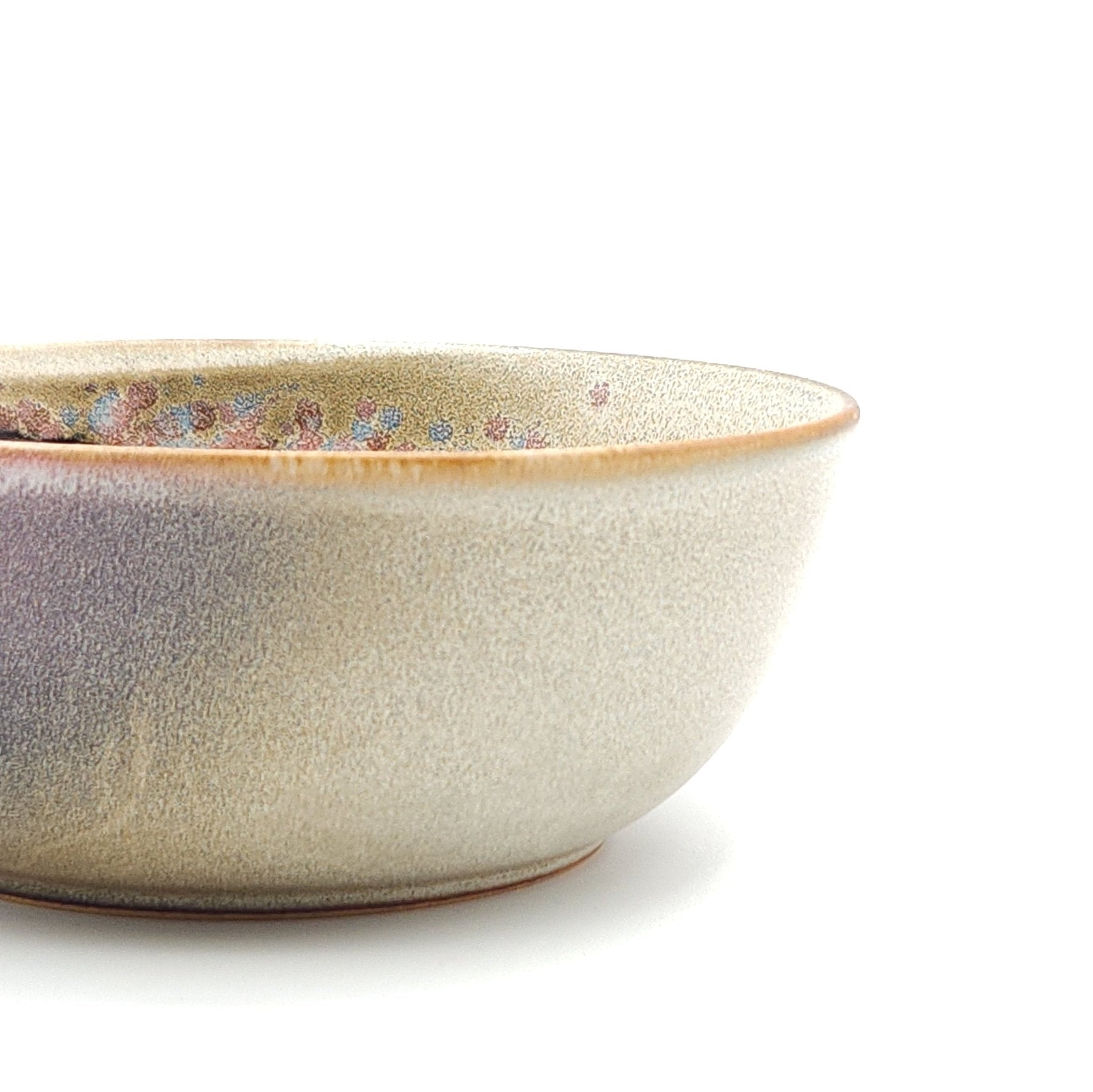 Authentic Japanese pottery salad bowl with cherry blossoms decoration. Pink and beige color. (side detail view 1).