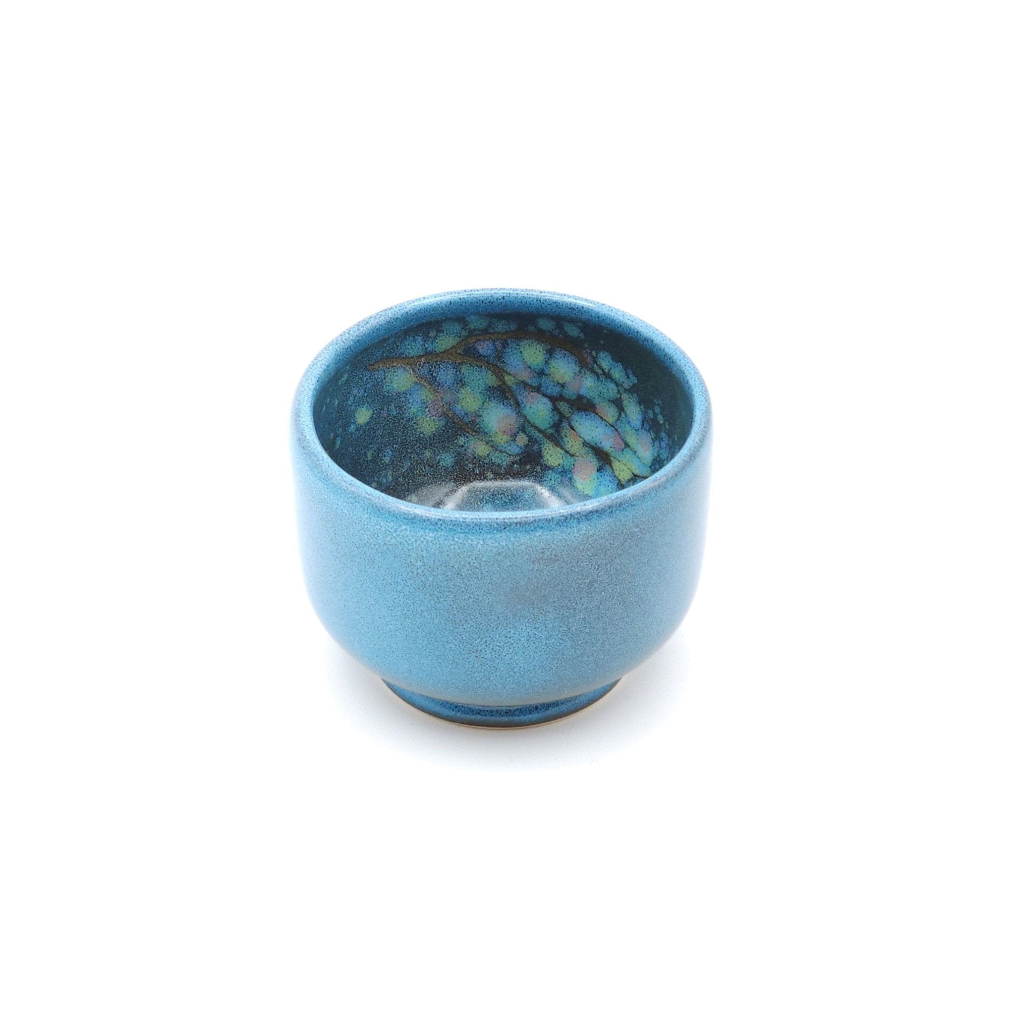 Authentic Japanese pottery teacup with tree pattern decoration. blue color. (front side view 1).
