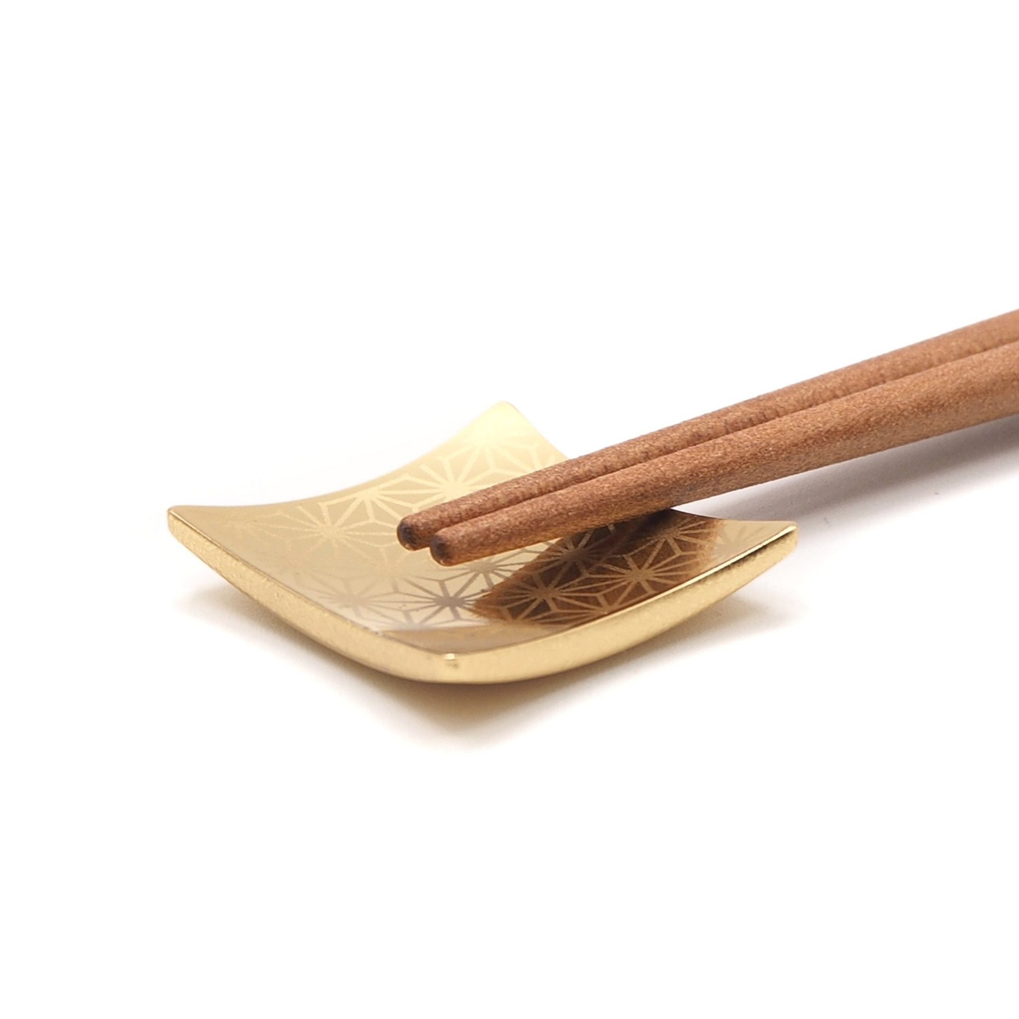 Detail of a point of red Japanese Chopsticks with golden motif on rest