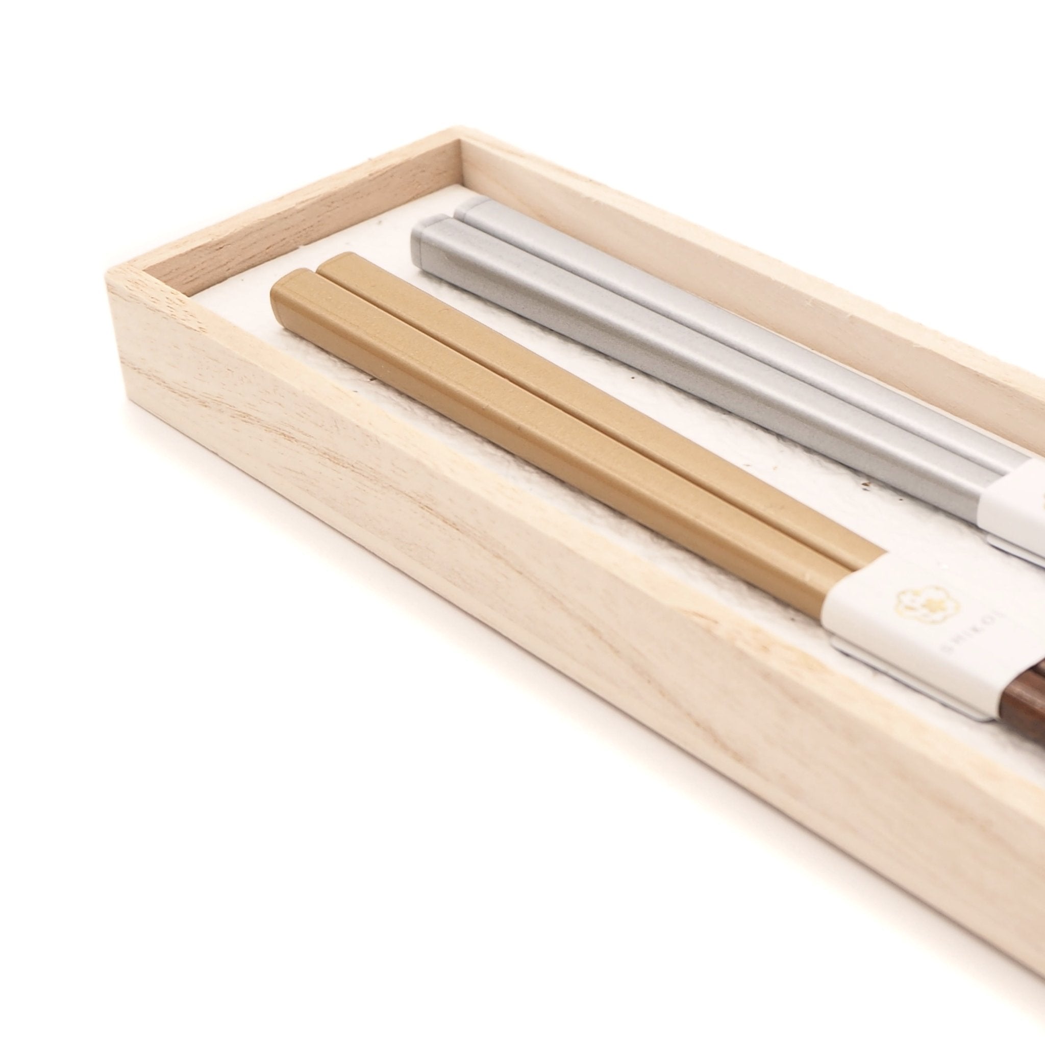 Silver and gold Japanese wooden chopsticks inside a box.