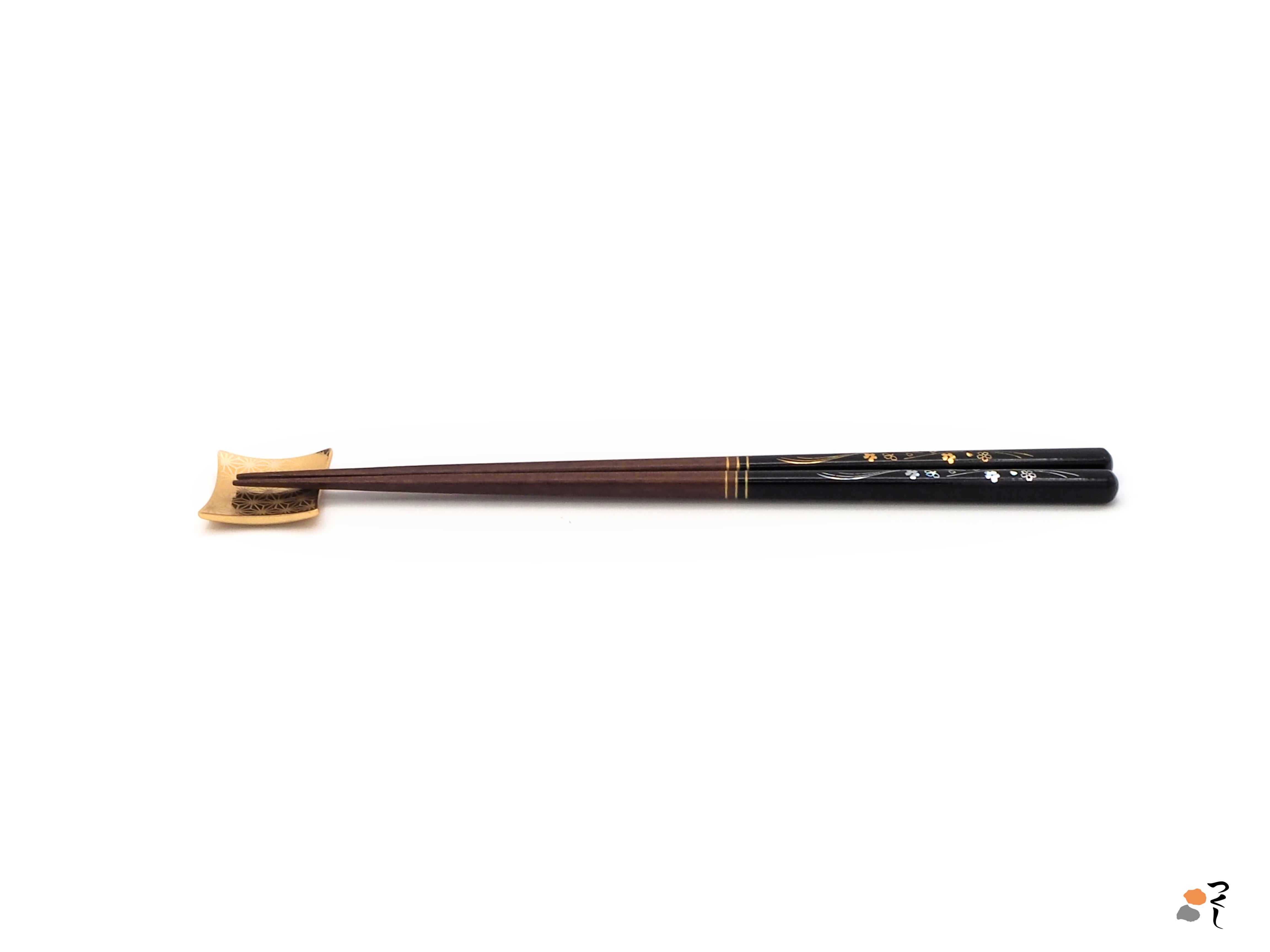 Side view of black Japanese chopsticks with cherry blossom motifs