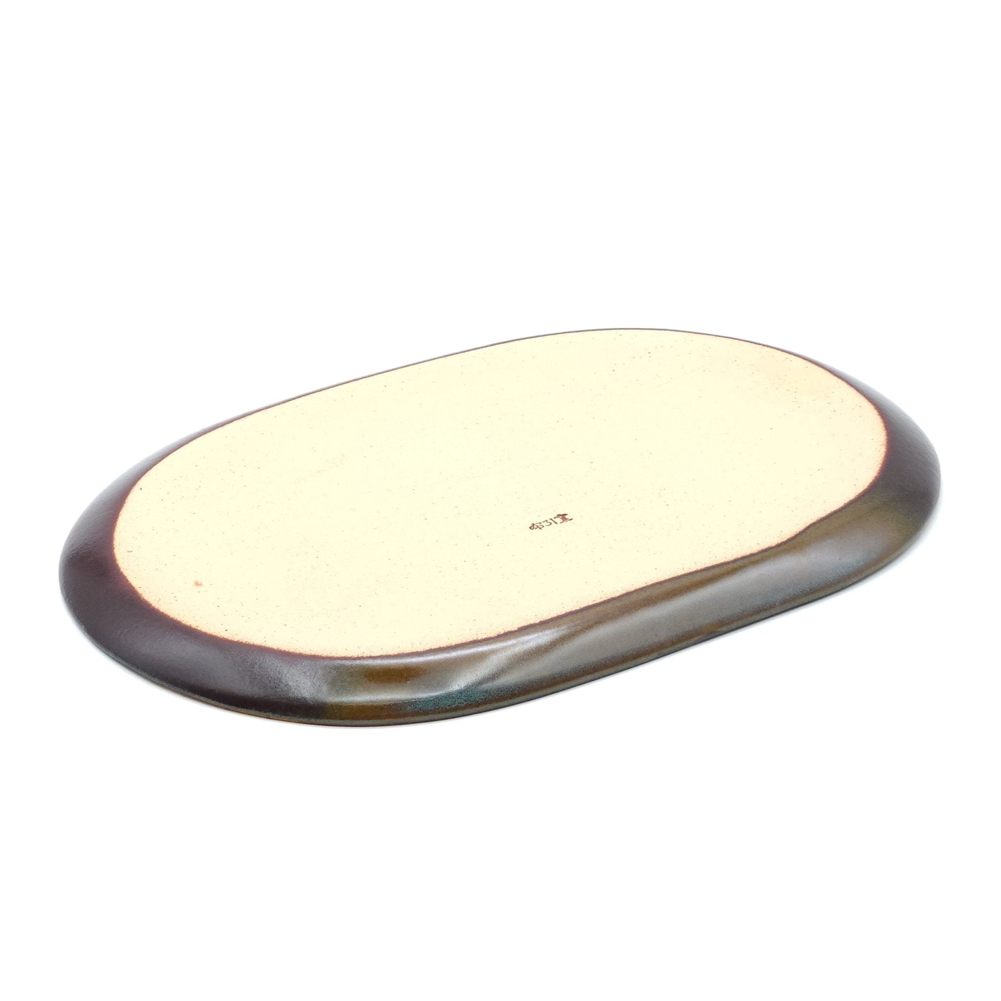 Bottom view of a Japanese plate made of pottery with cherry blossoms motif in green background.