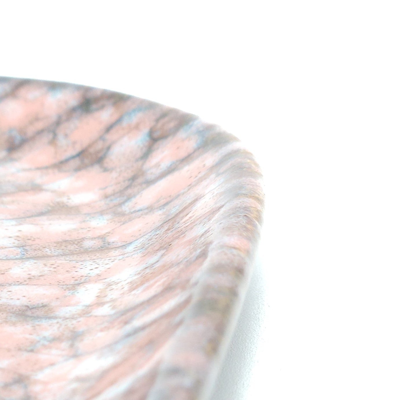 A detail of a Japanese plate made of pottery with cherry blossoms motif in pink background.