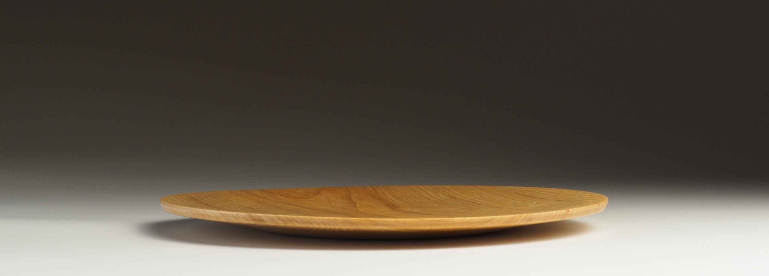 Cherry wood wooden Plate black gradation background. Tsukushi