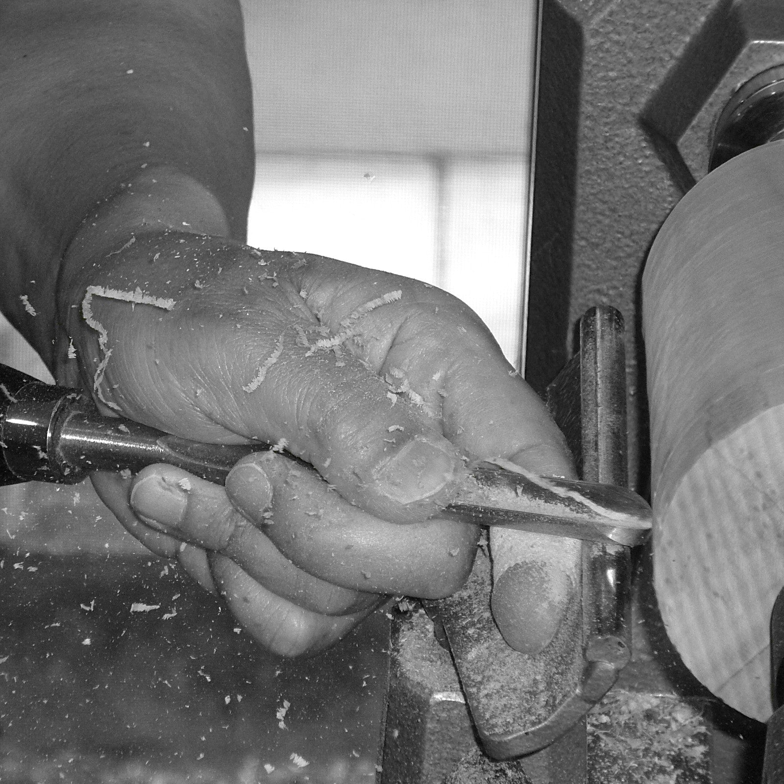 Close-up of a hand shaping Japanese wooden guinomi cup, Tsukushi