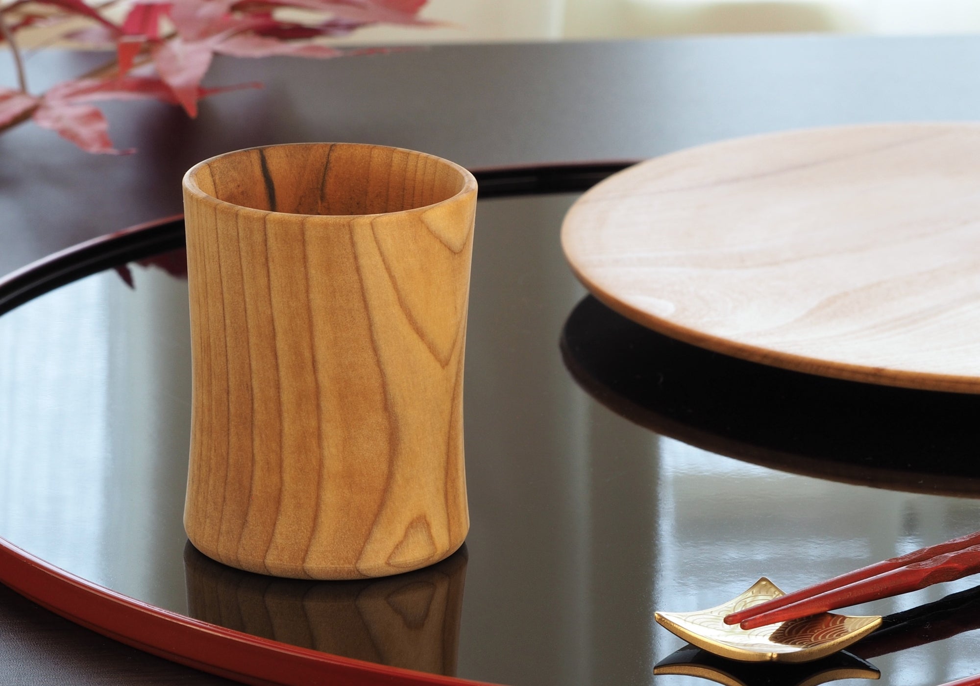 Japanese Wooden Sake cup on black plate, Tsukushi