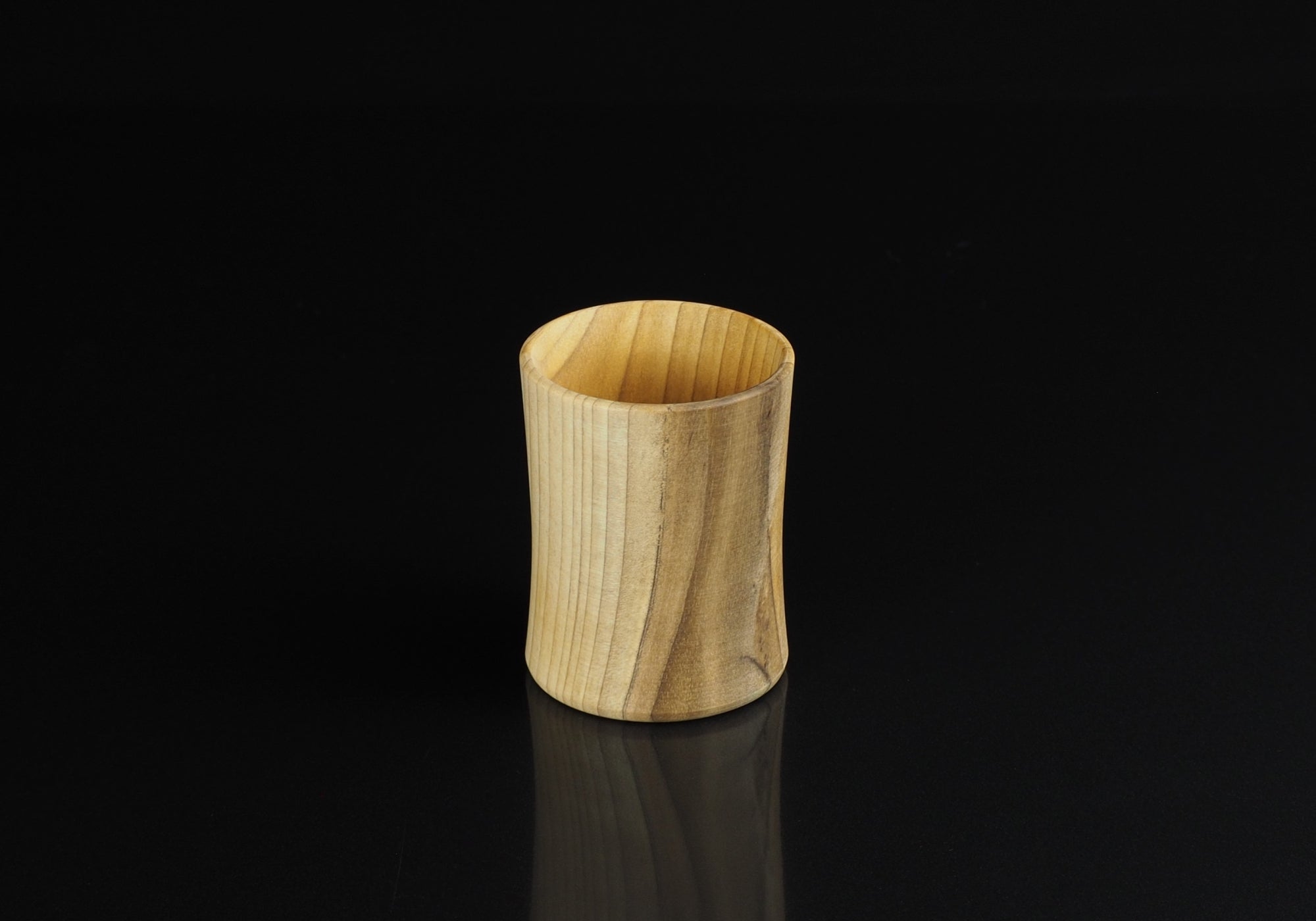 Japanese handcrafted wooden Sake cup background black. Tsukushi