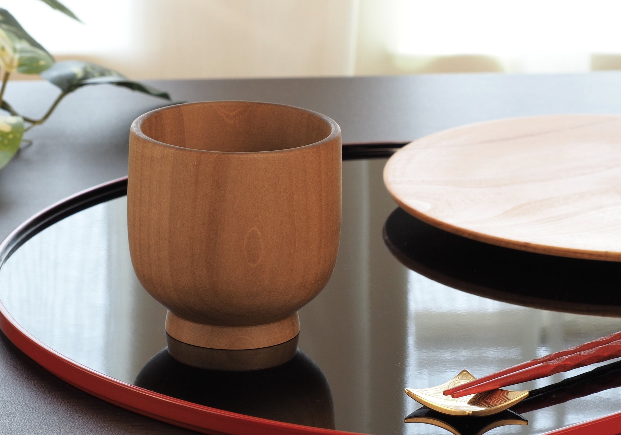 A Japanese handcrafted wooden cup on a lifestyle background. Tsukushi