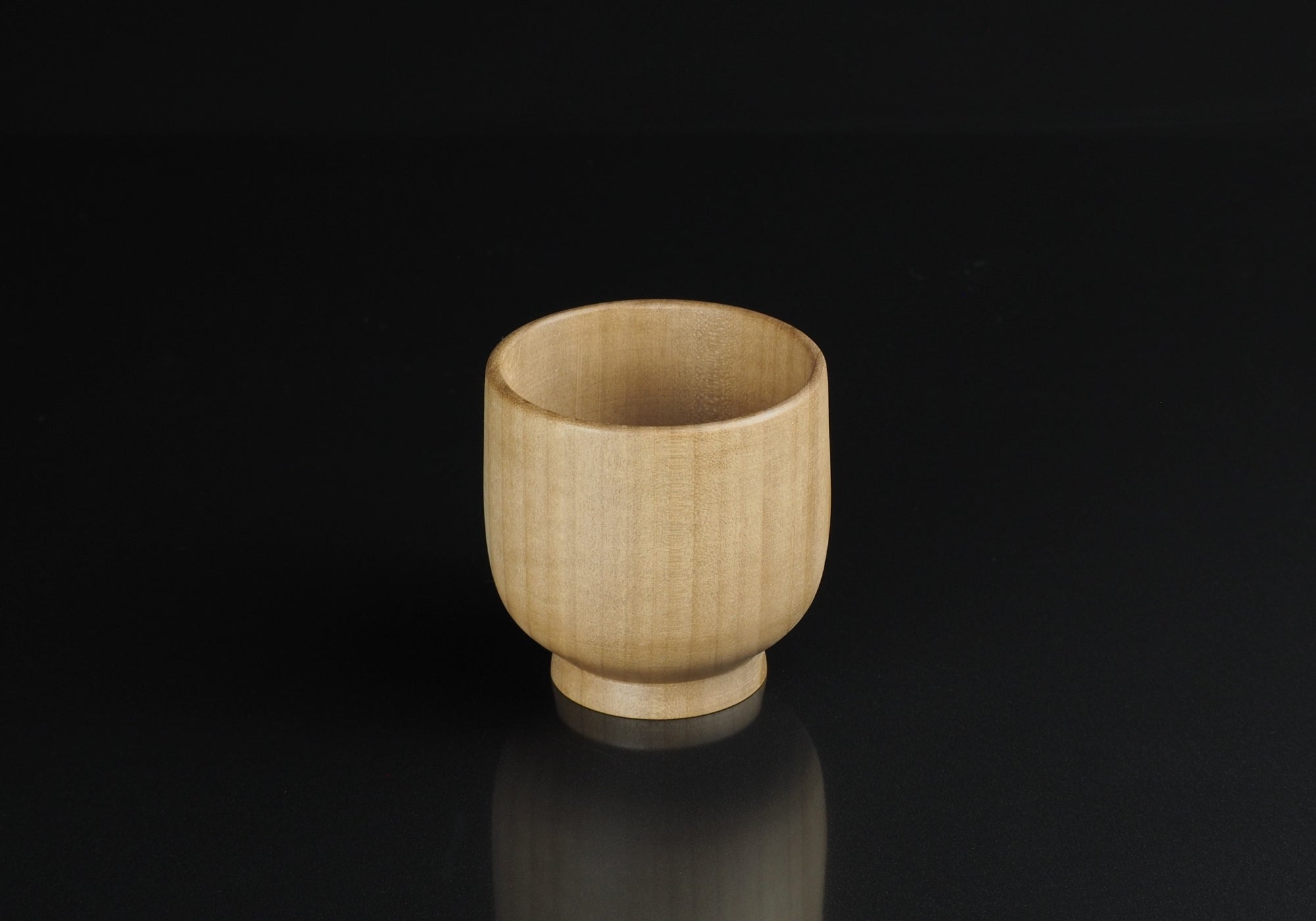 Japanese handcrafted wooden Teacup black background. Tsukushi