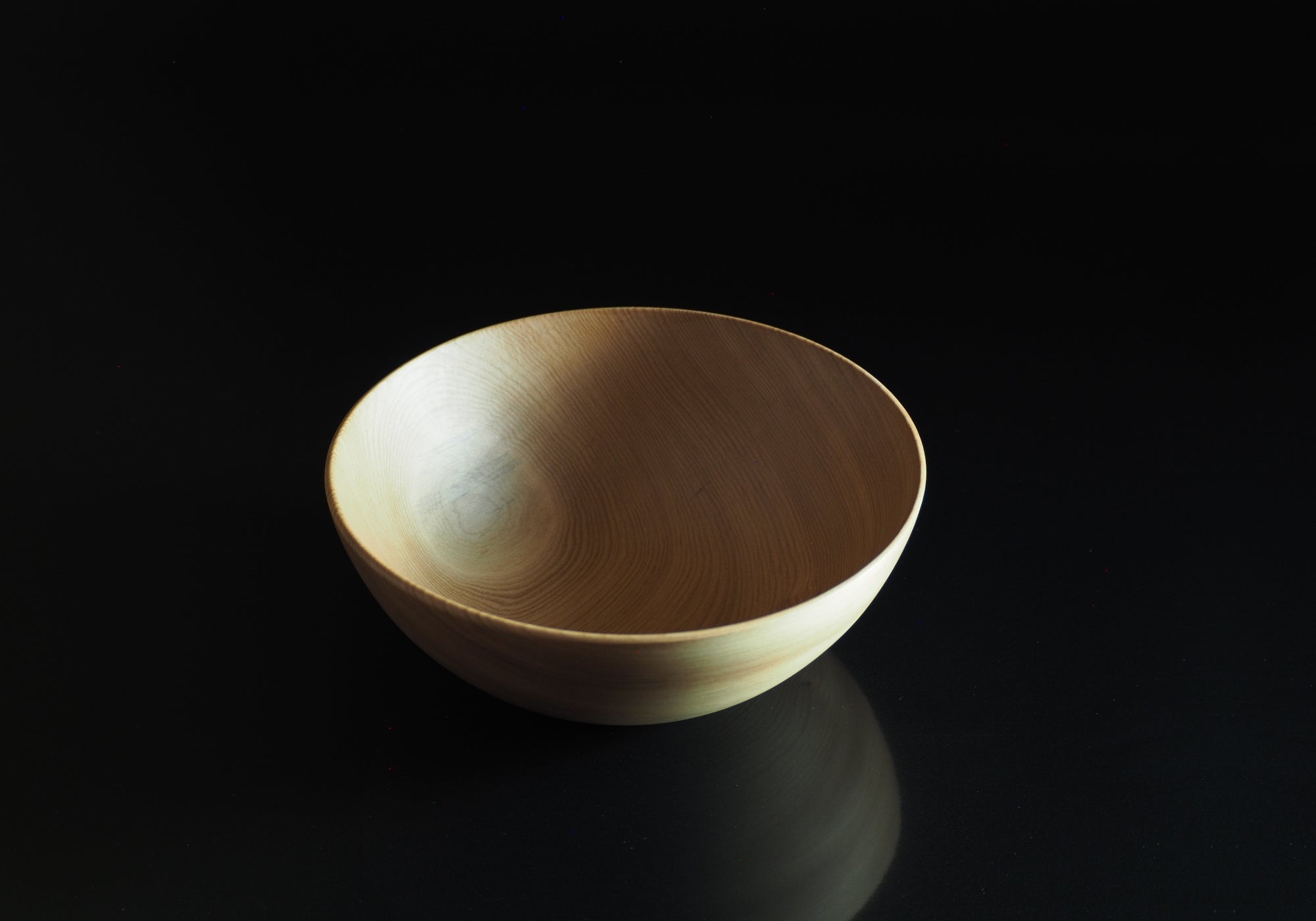 Japanese wooden bowl on a black background. Tsukushi