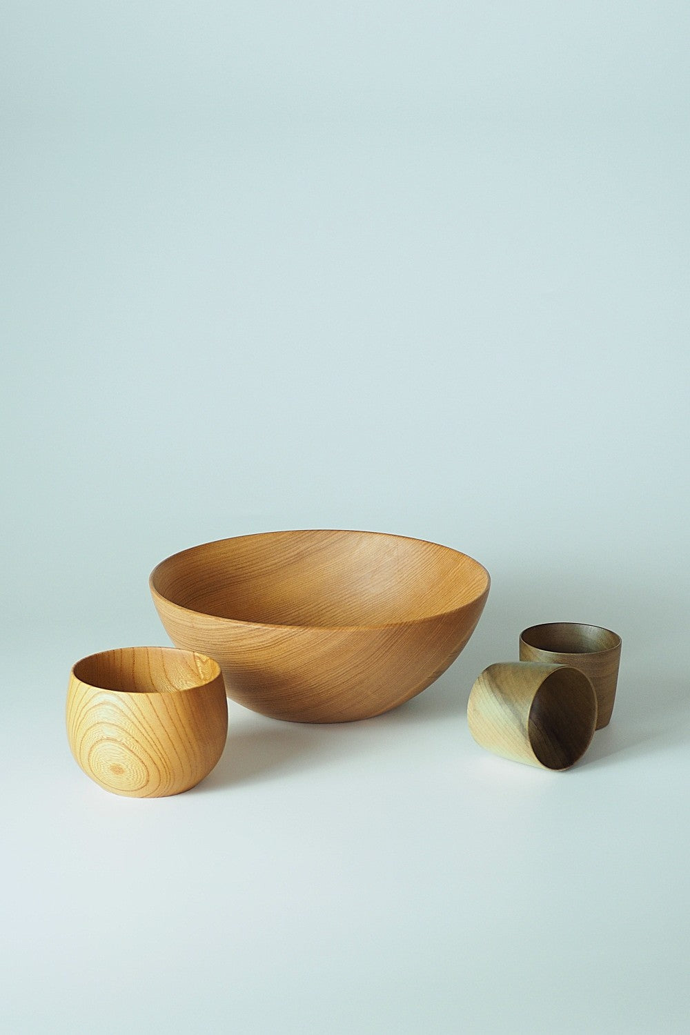Set of Japanese wooden bowls and cups on a light background. Tsukushi