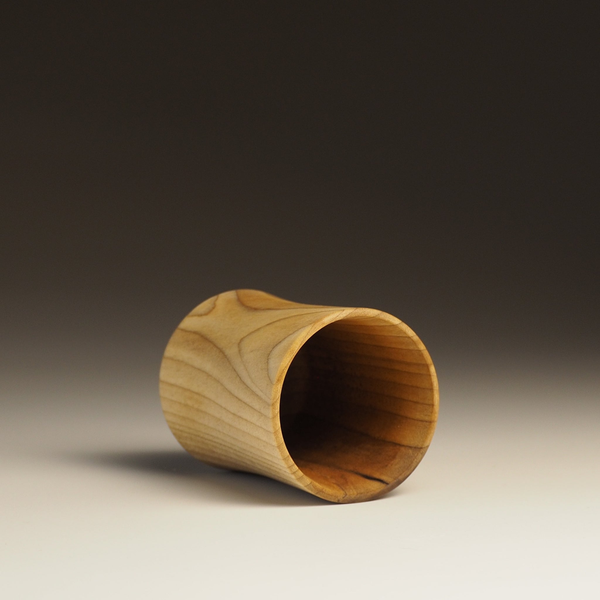 Japanese handcrafted wooden Sake cup on gradation background inside. Tsukushi