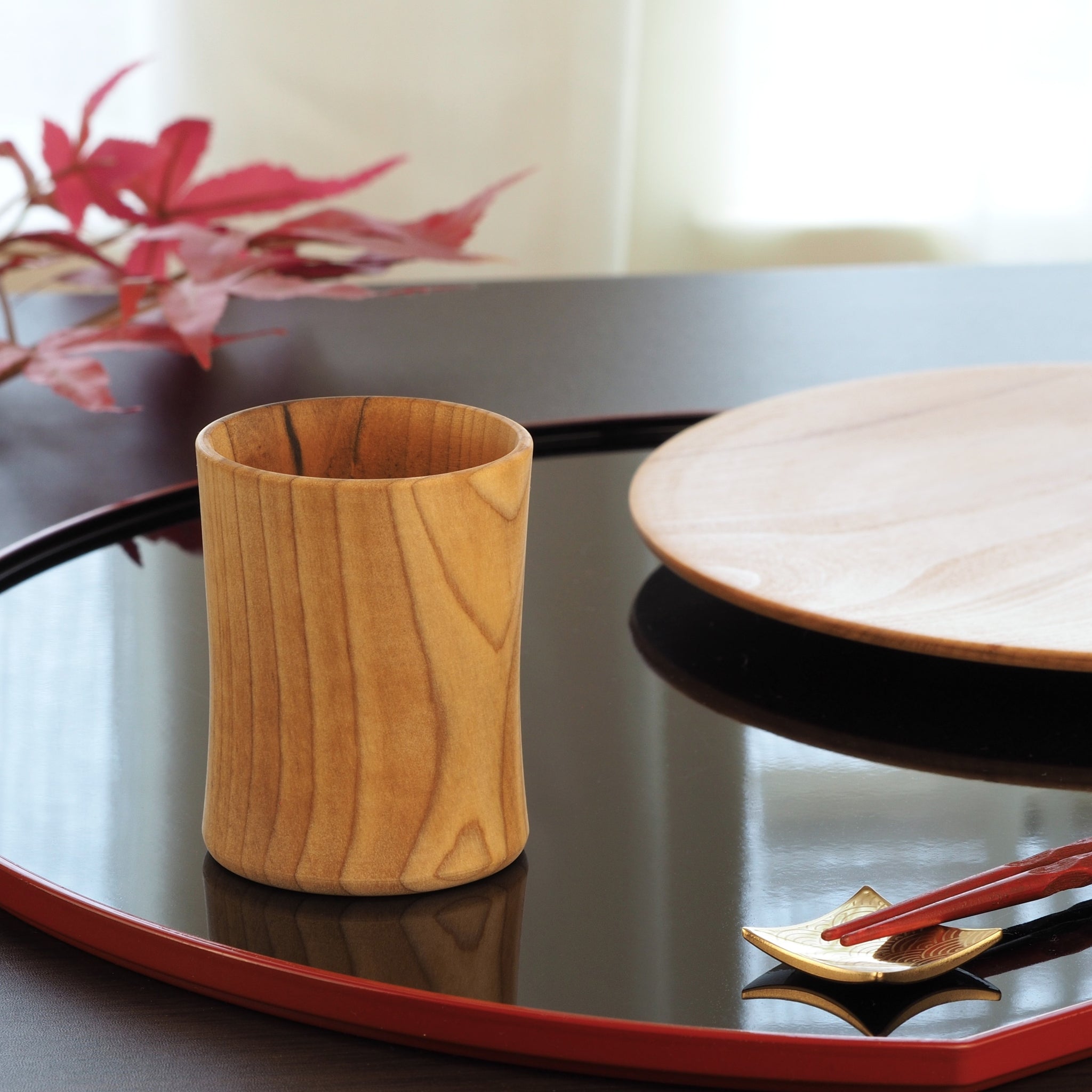 Japanese handcrafted wooden Sake cup on lifestyle background. Tsukushi