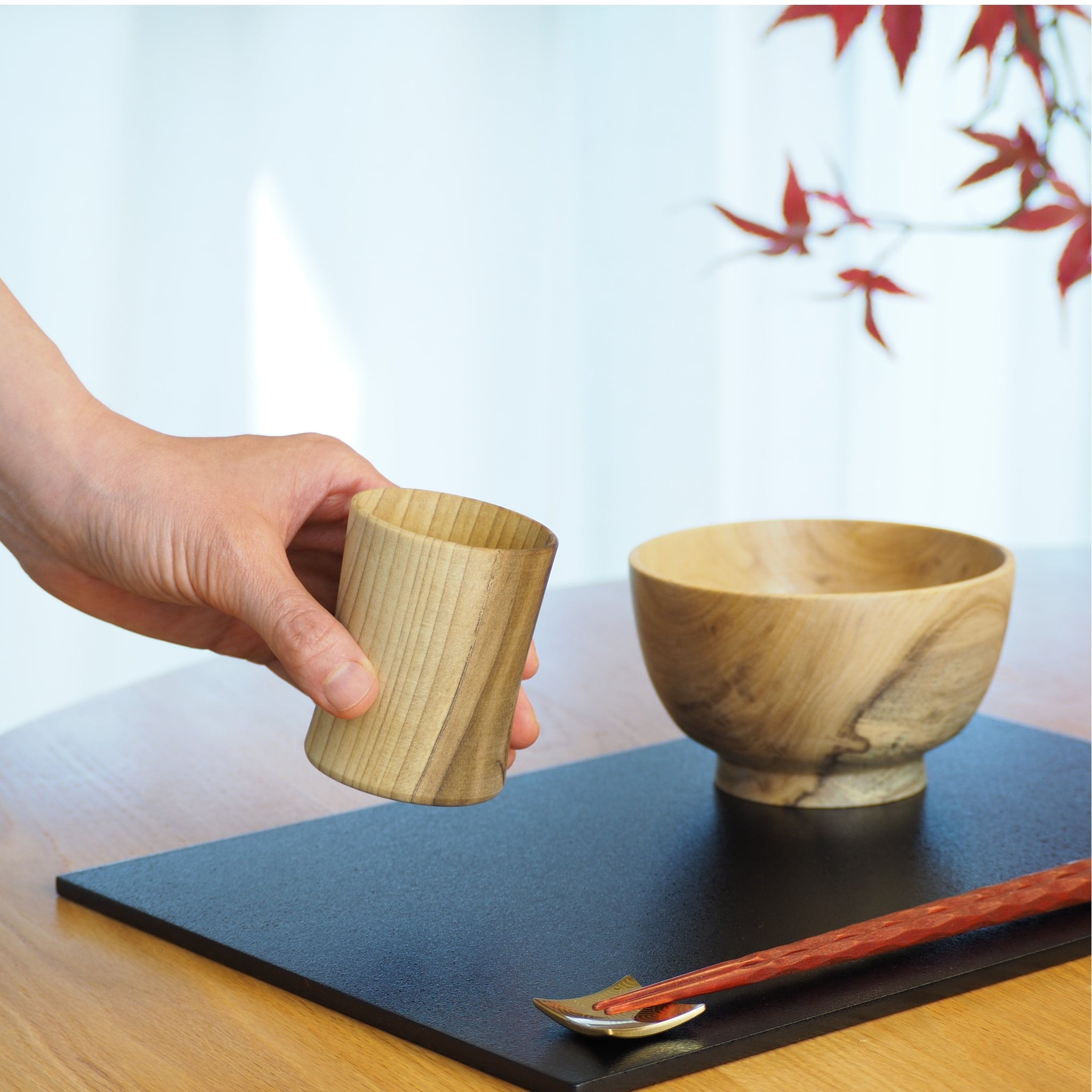 Japanese handcrafted wooden Sake cup and wood bowl on lifestyle background. Tsukushi
