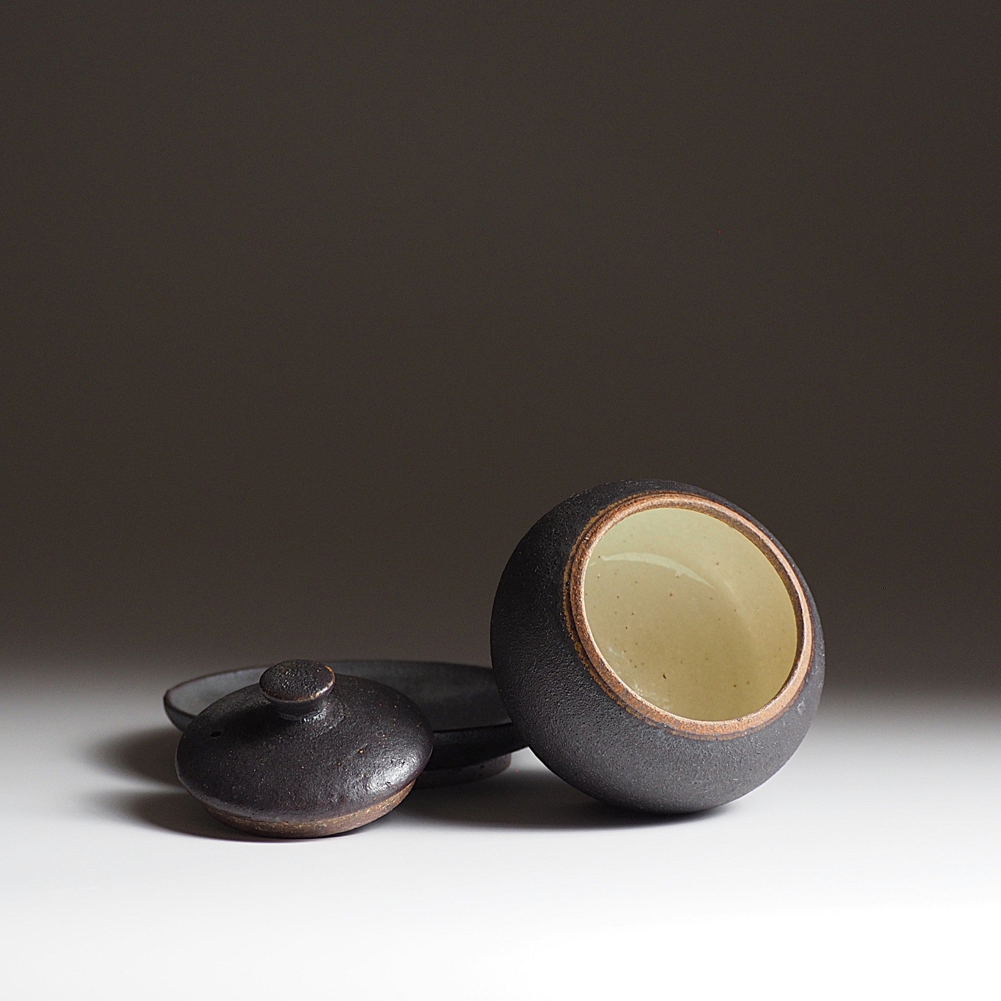 Display of a Chawanmushi bowl, lid and saucer on faded black background. Tsukushi