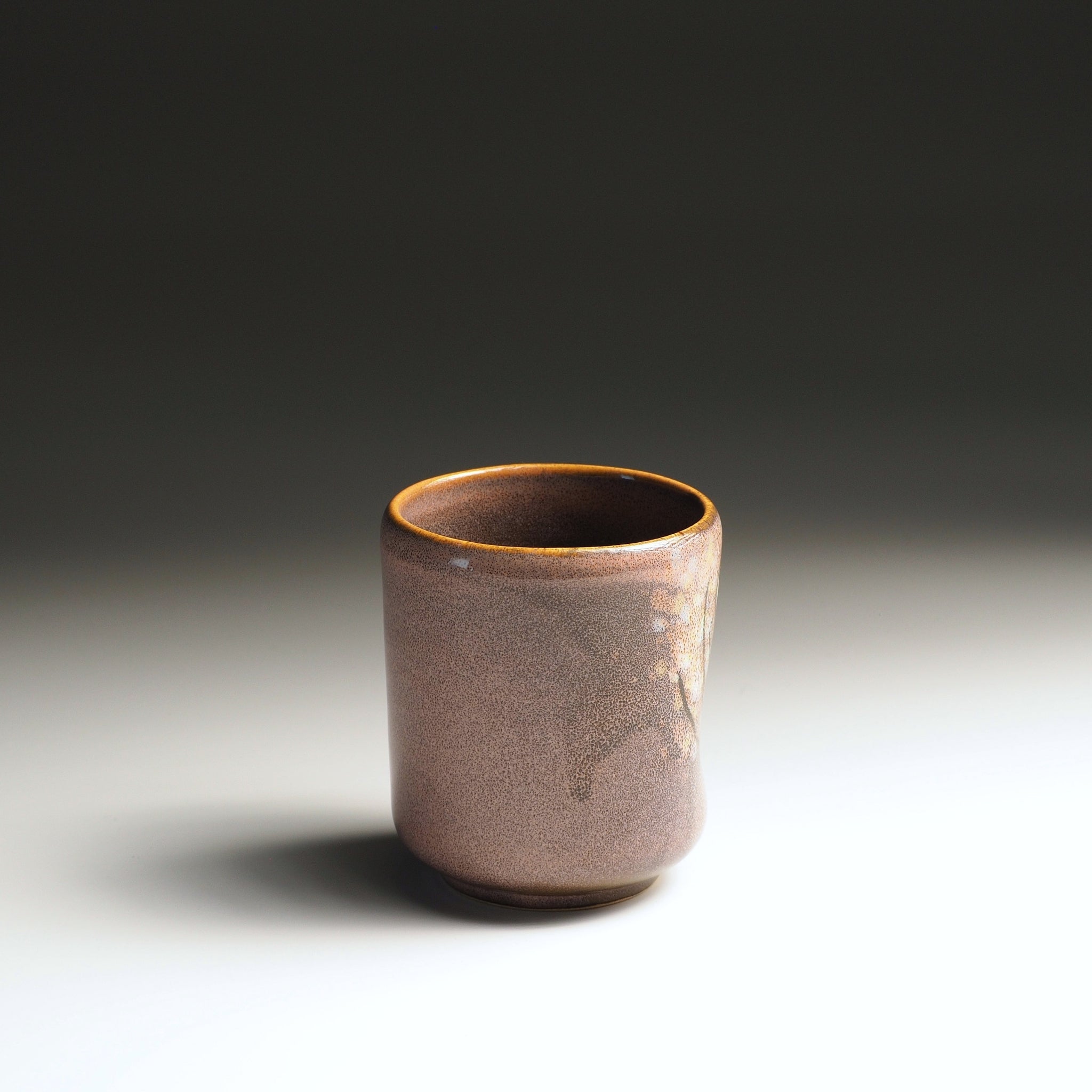 Angled view of a pink Japanese yunomi showing the carved thumb hollow for grip, Tsukushi