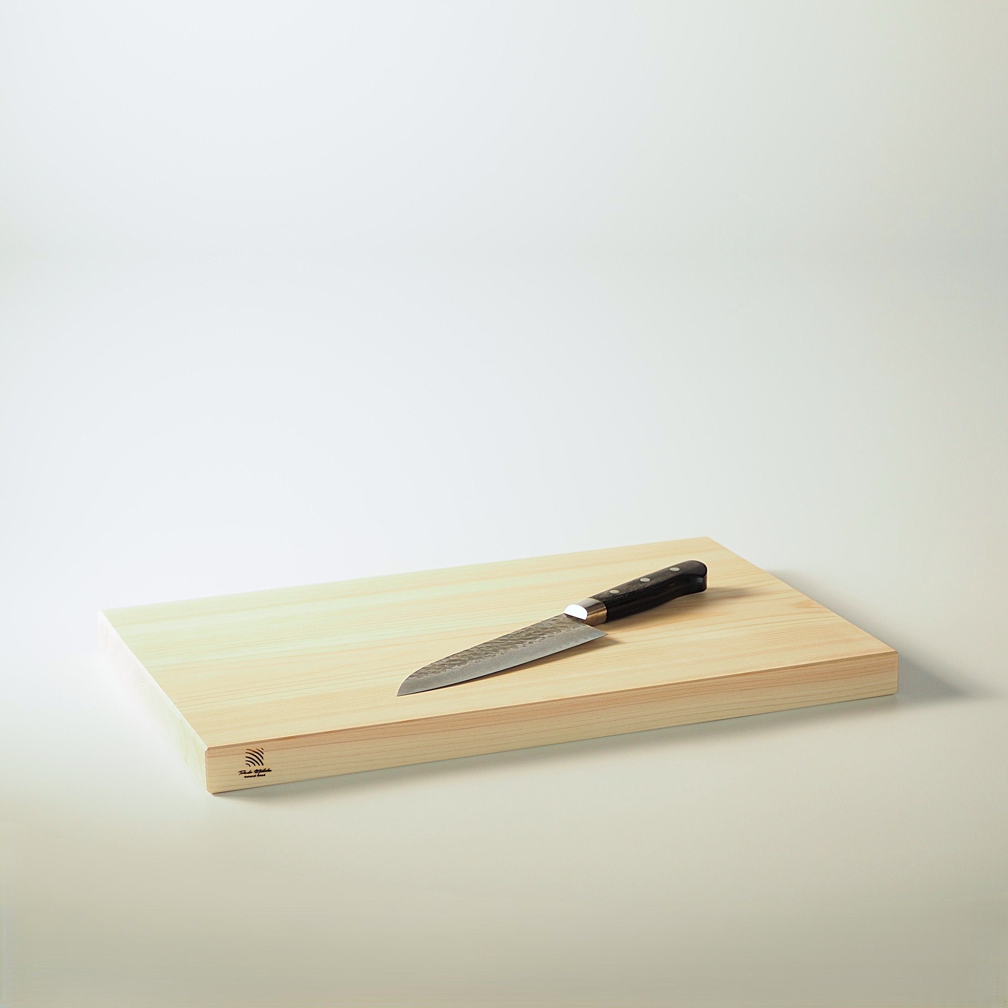 Japanese wooden cutting board with a knife on a light background. Tsukushi