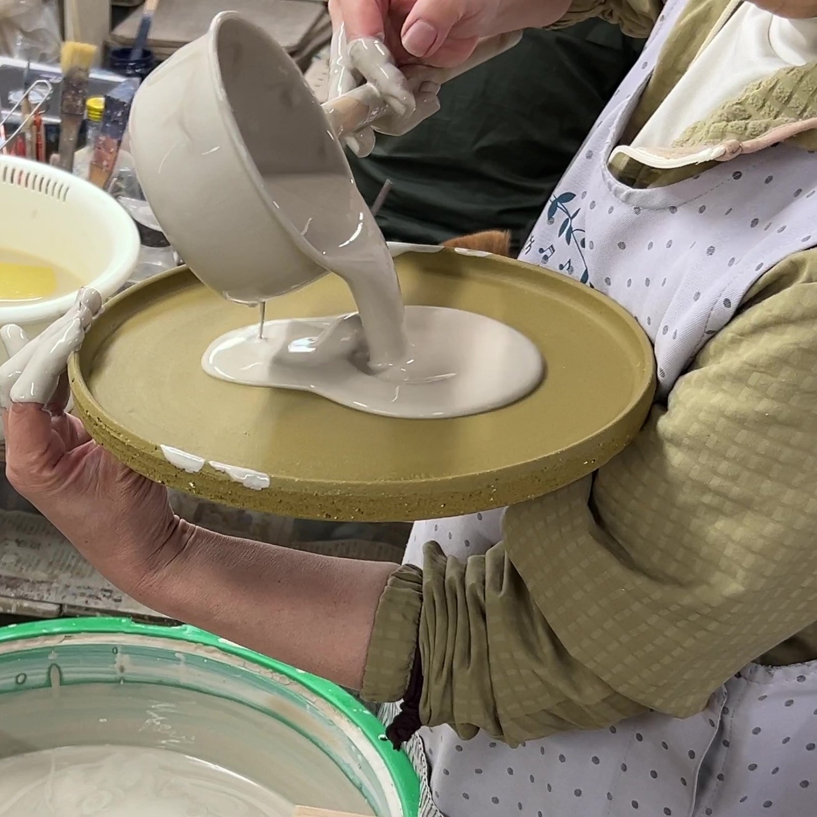 Glazing a Japanese pottery plate. Tsukushi