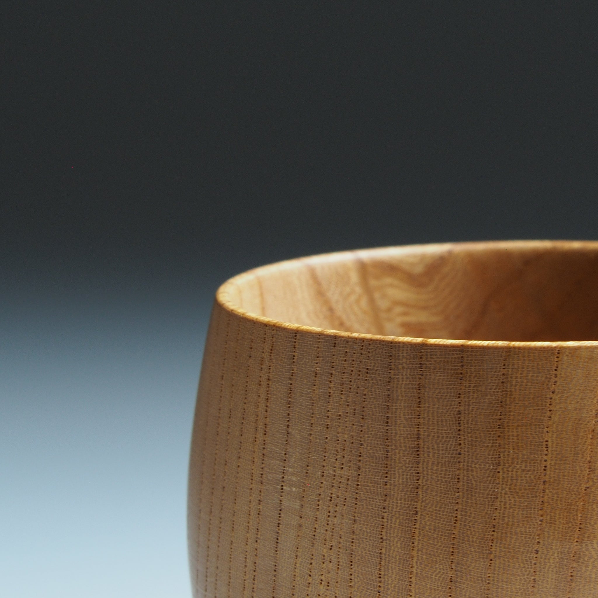 Close-up of a Japanese wooden cup with a gradient background. Tsukushi