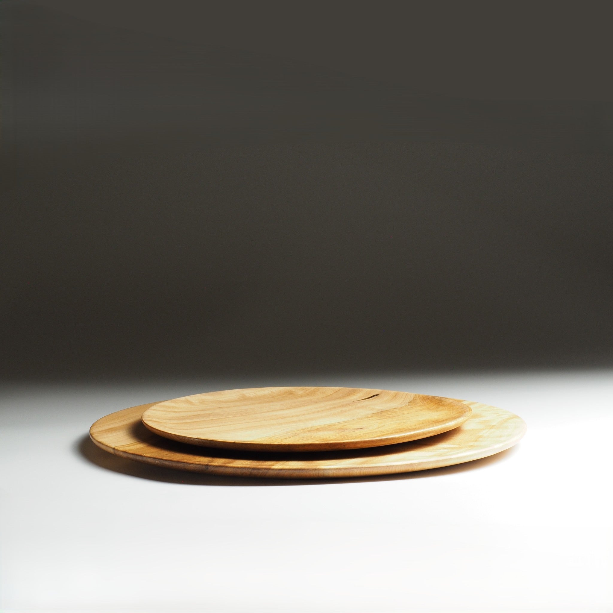 Two Japanese wooden plates stacked on a dark background. Tsukushi