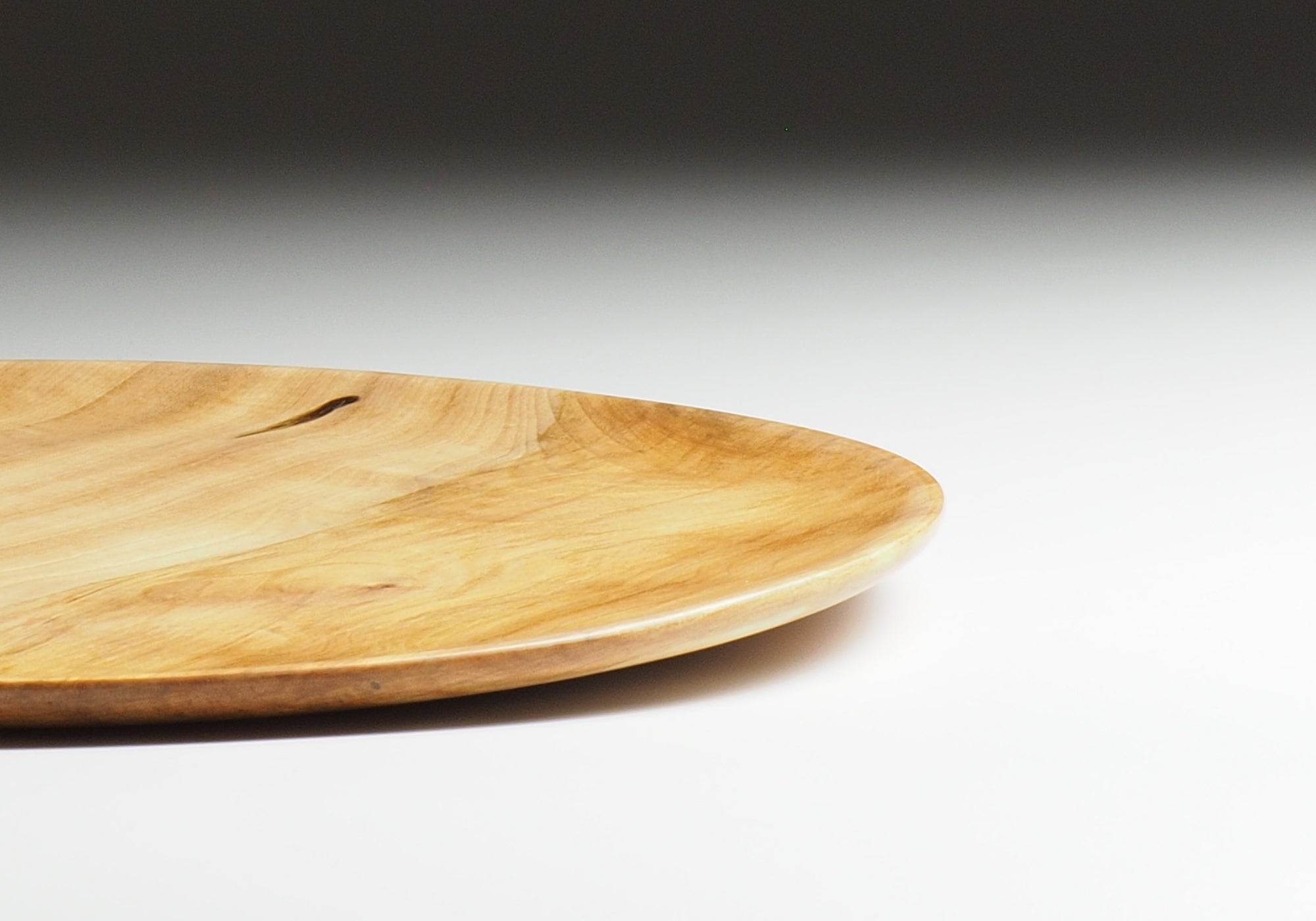 Detail of Japanese wooden dinner plate on a beige background. Tsukushi