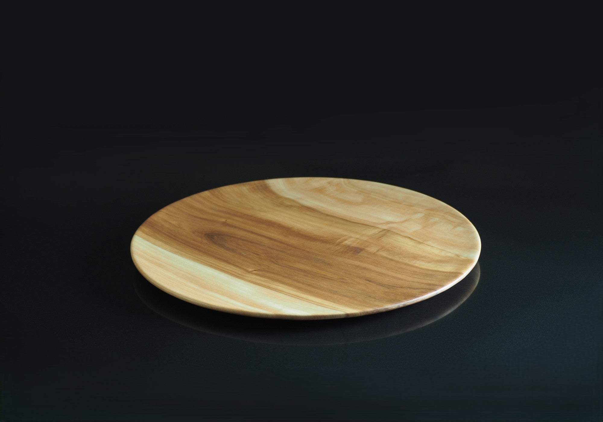 Japanese wood plate on a reflective black surface. Tsukushi