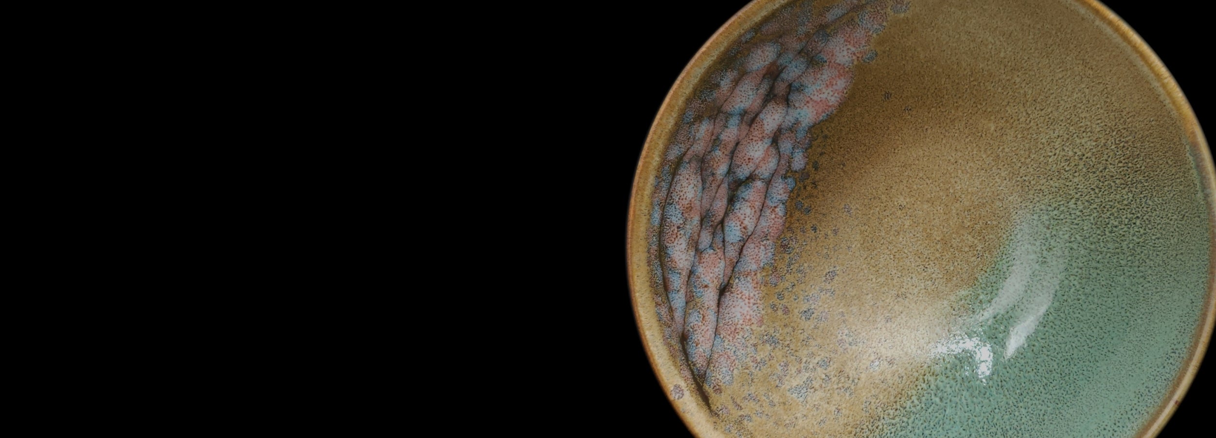 Green Japanese pottery bowl, black background (landscape). Tsukushi