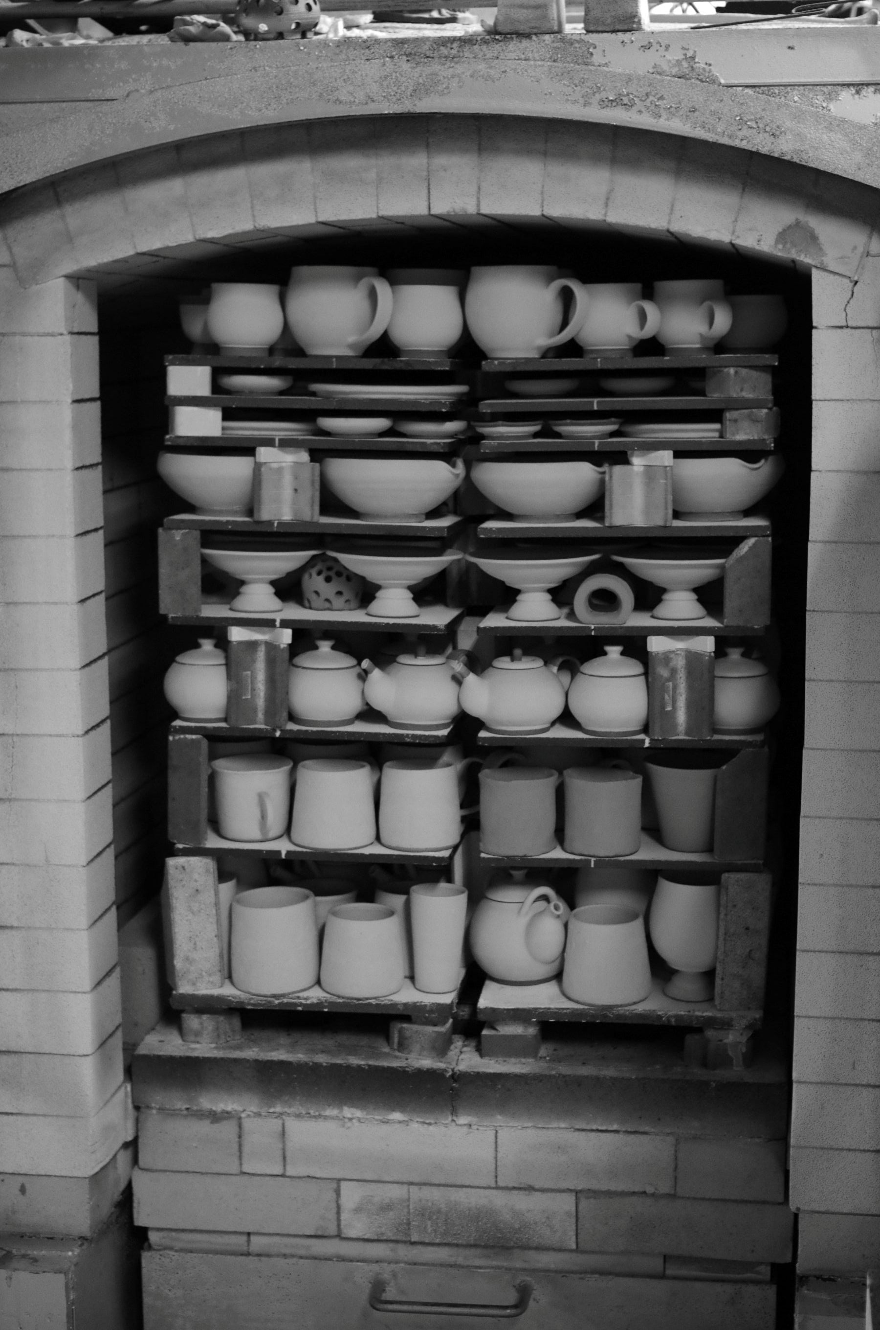 Black and white image of Stacked Japanese ceramics in a kiln, Tsukushi