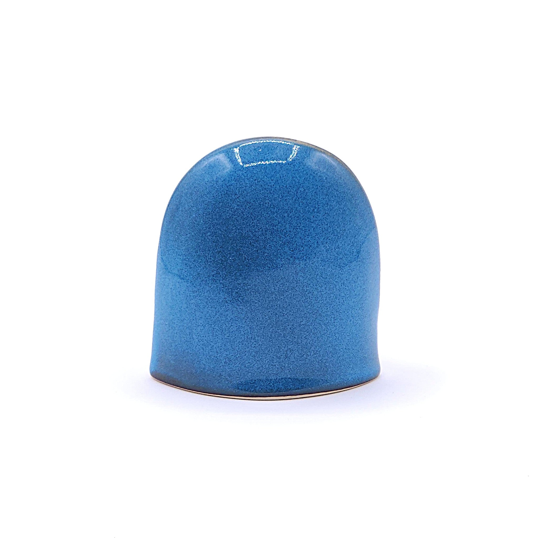 A back view of handcrafted ceramic figurine of an owl with a blue. Tsukushi