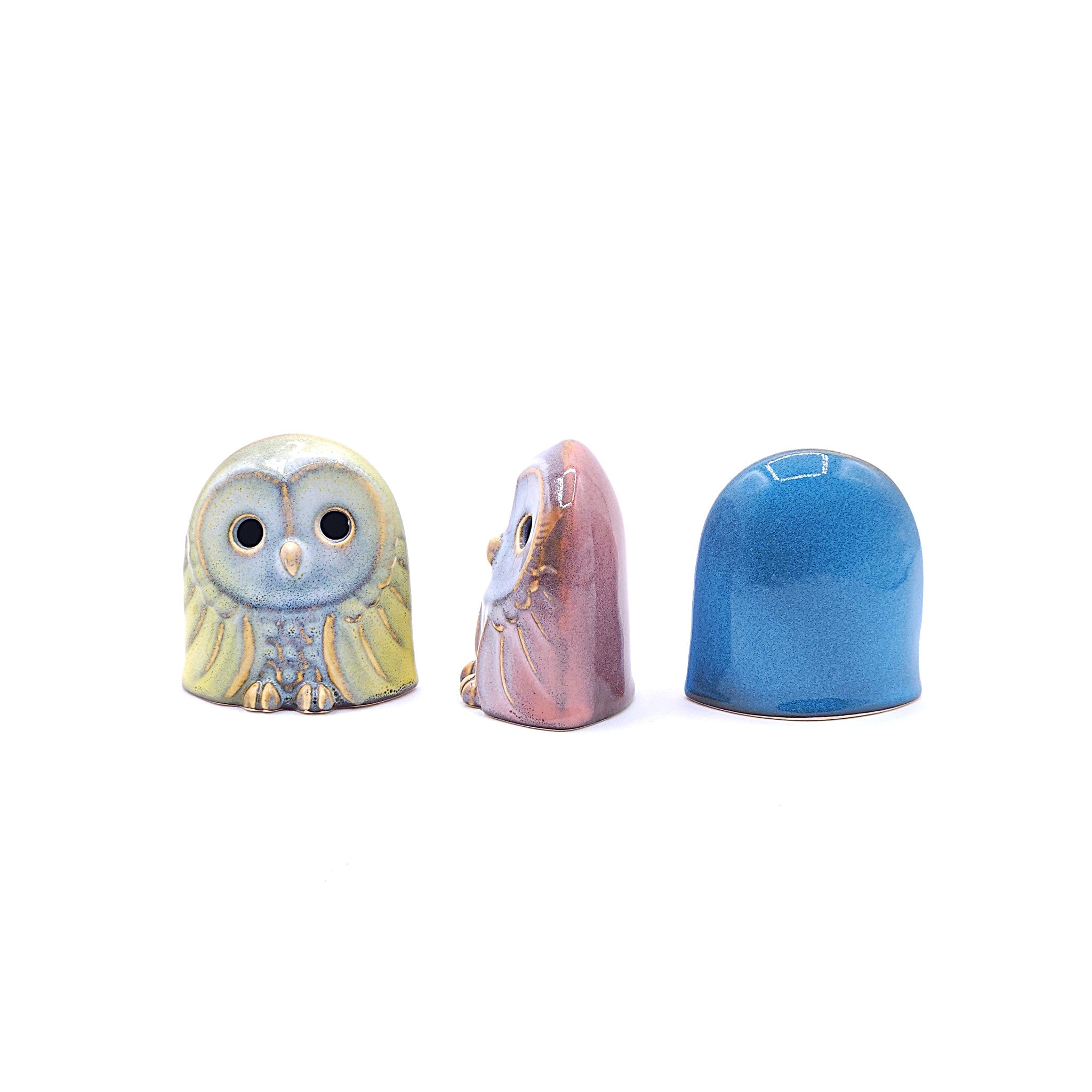 Set of three handcrafted ceramic owl figurines in pink, blue, and yellow. Tsukushi