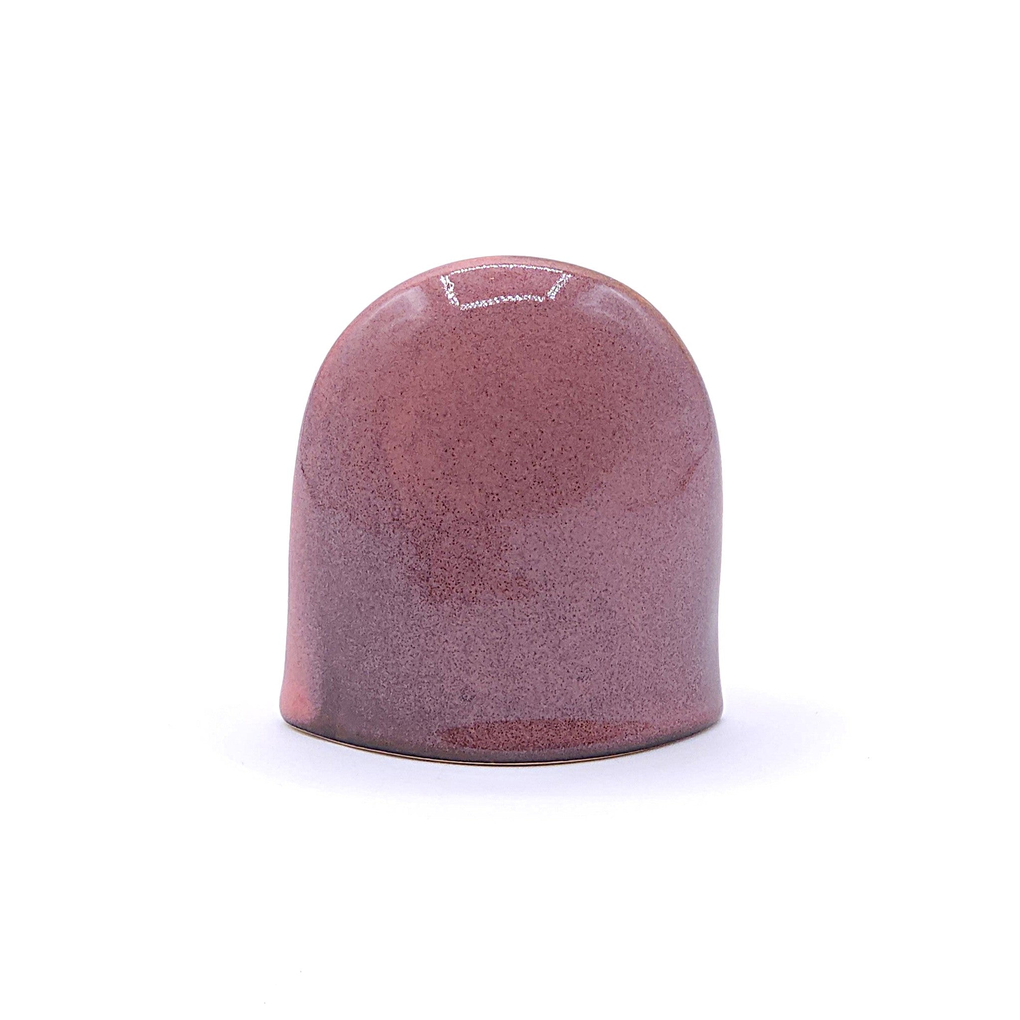 A back side of a handcrafted ceramic figurine of an owl with a pink. Tsukushi