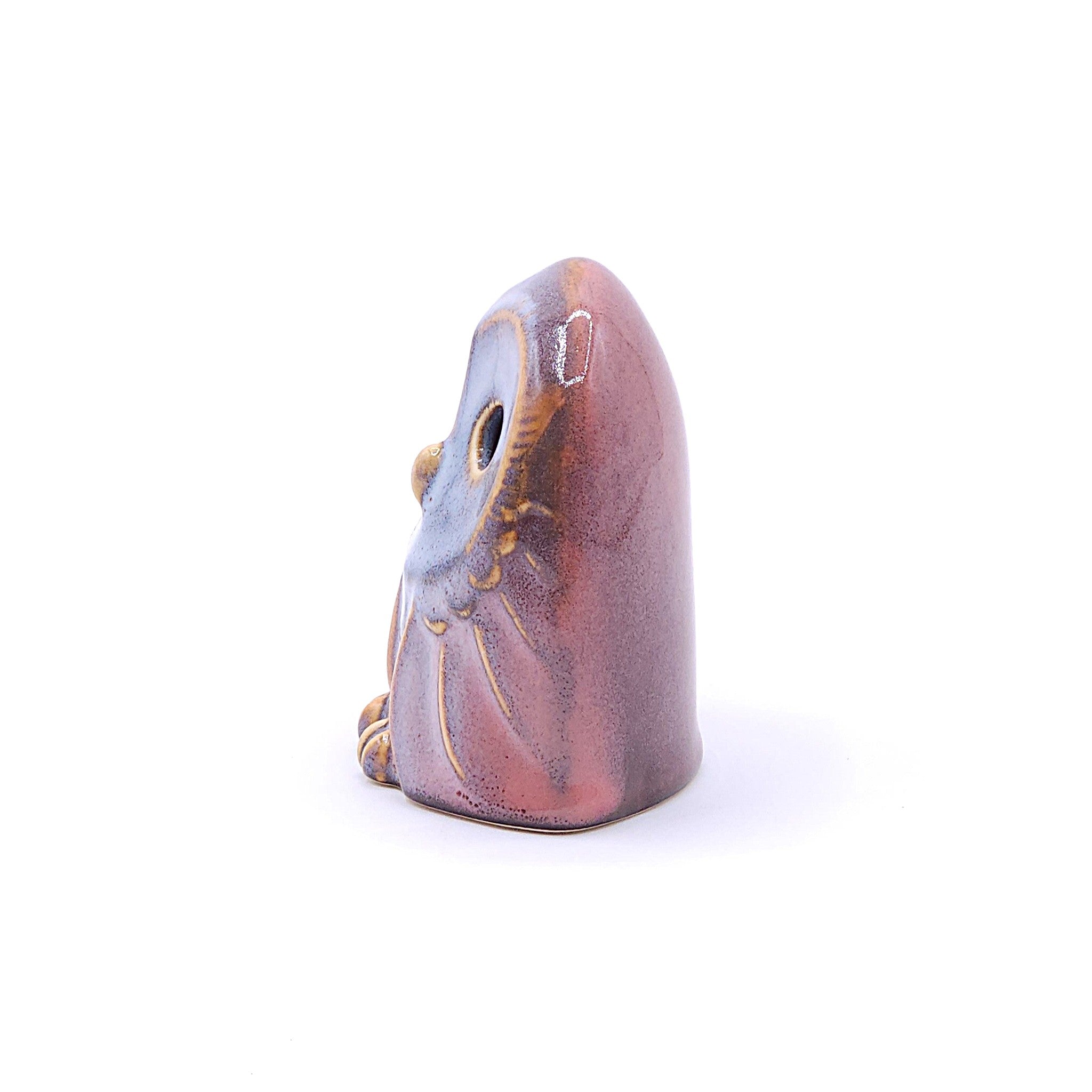 A left side view of a handcrafted pottery figurine of an owl with a pink. Tsukushi