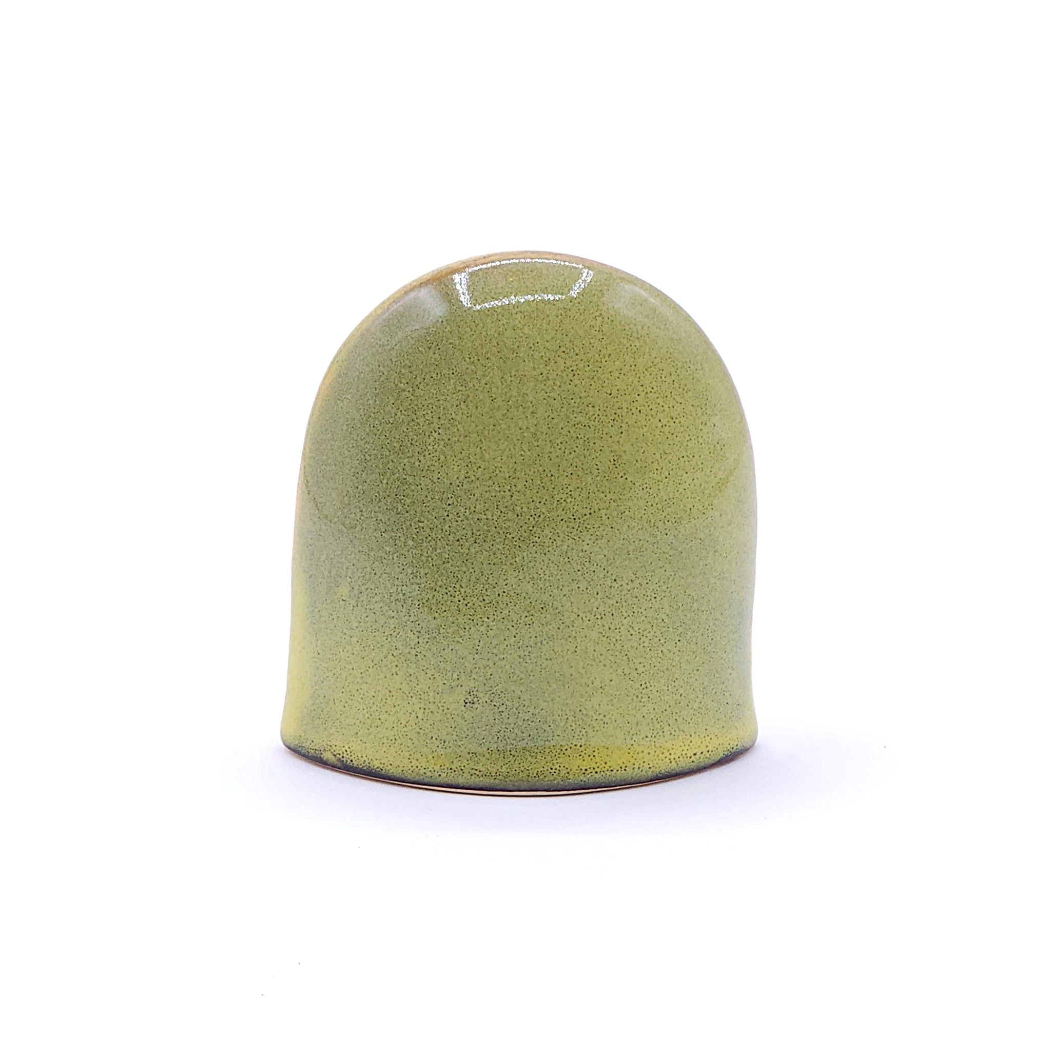 A back side of a handcrafted ceramic figurine of an owl with a yellow. Tsukushi