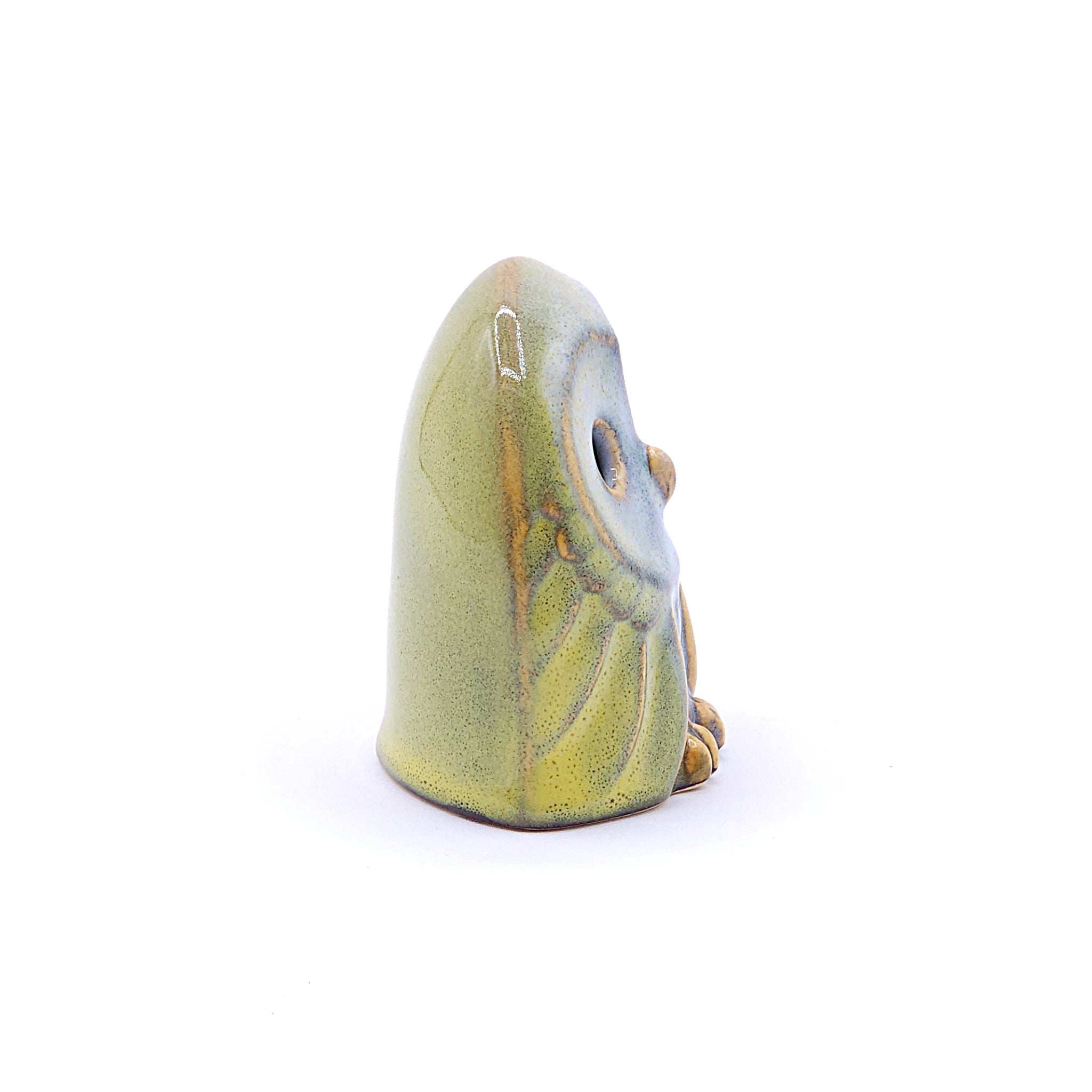 A right view of a handcrafted ceramic figurine of an owl with a yellow. Tsukushi