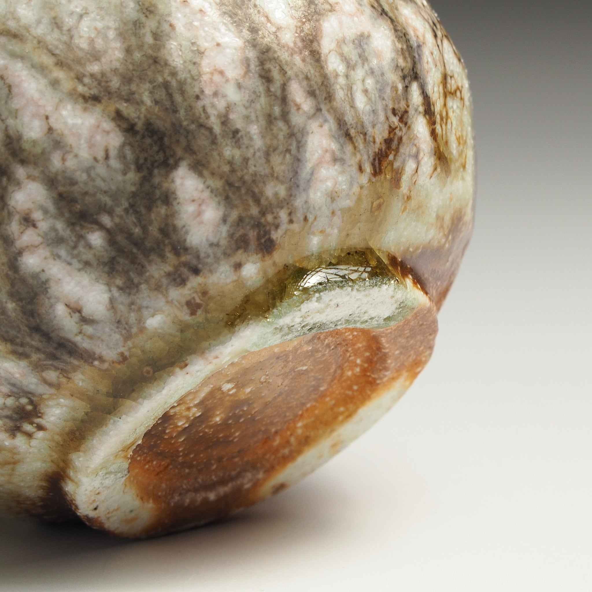 Close-up of the base of a Ryoen Shigaraki yunomi showing the textured glaze and exposed clay foot.
