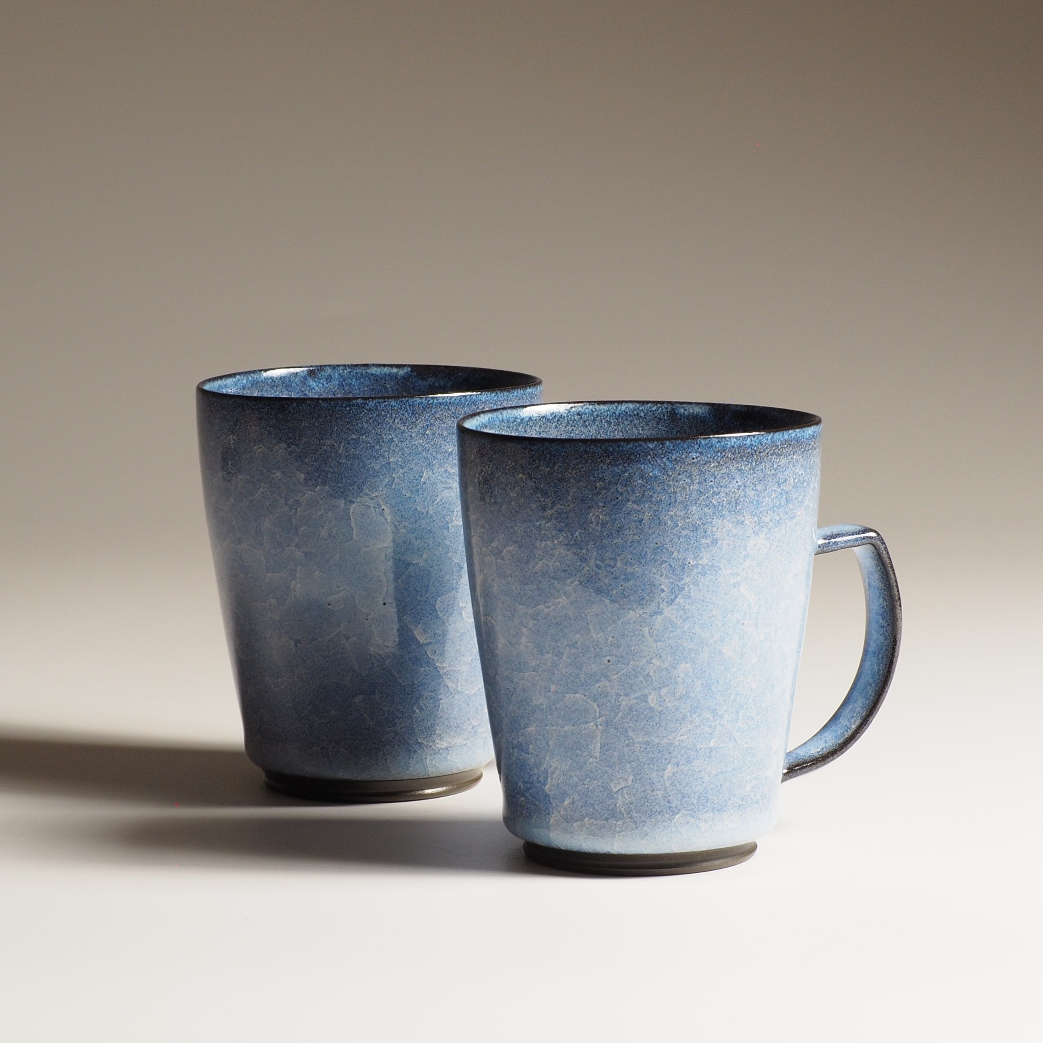 Japanese handcrafted crazing ceramic Tea mugs beige background from side, Tsukushi