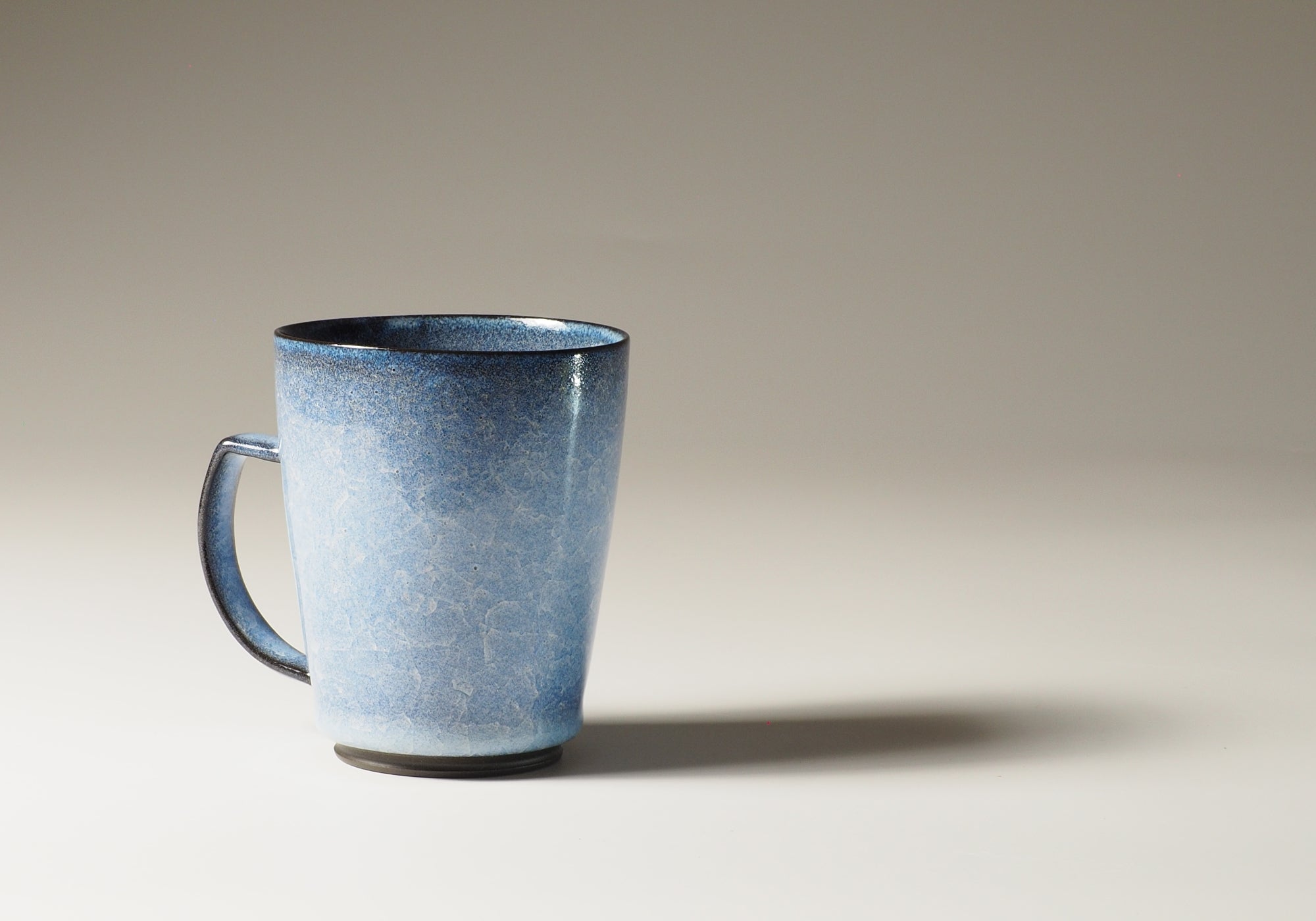Japanese handcrafted crazing ceramic Tea mugs beige gradation background with shadow from side, Tsukushi