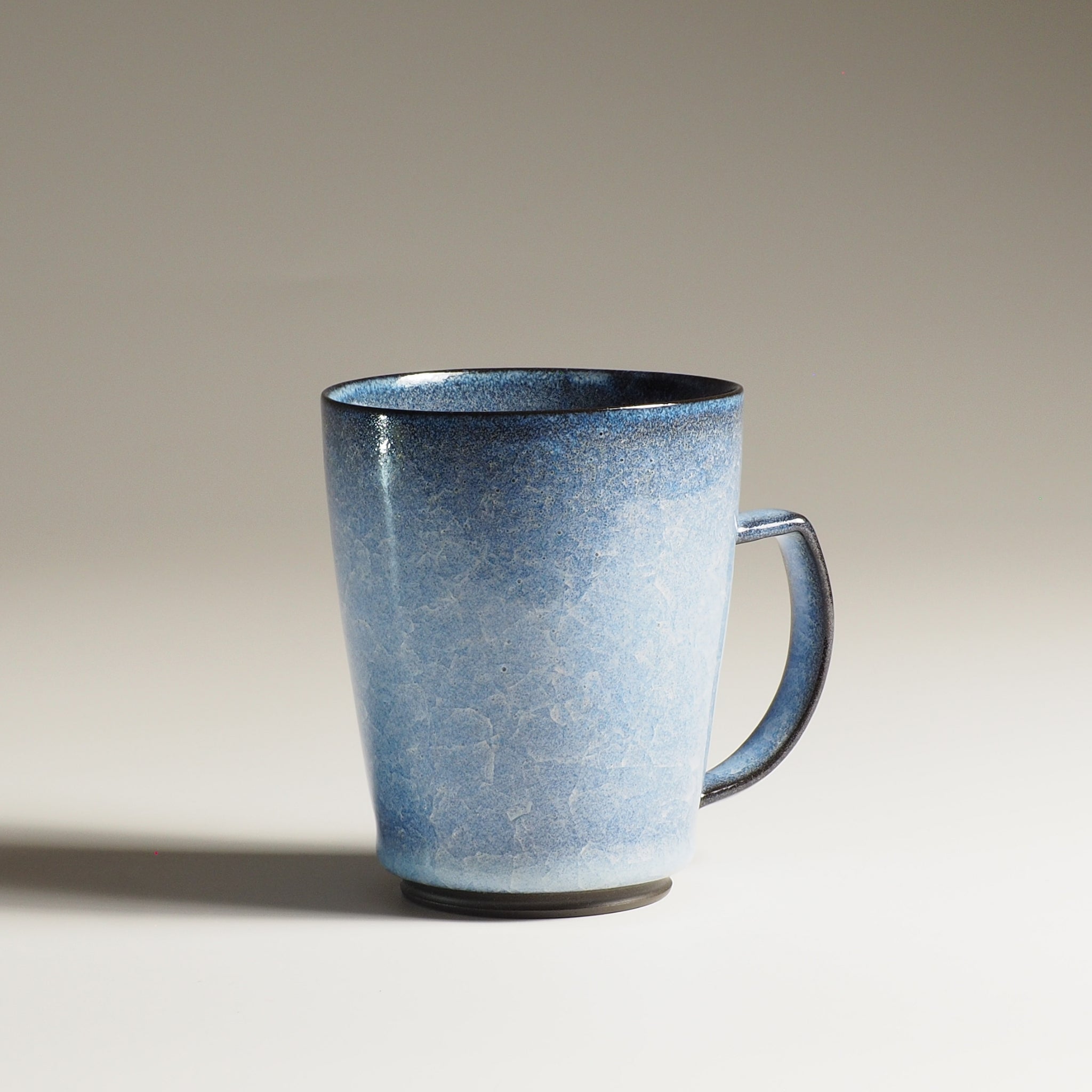 Japanese handcrafted crazing ceramic Tea mug beige background from side, Tsukushi