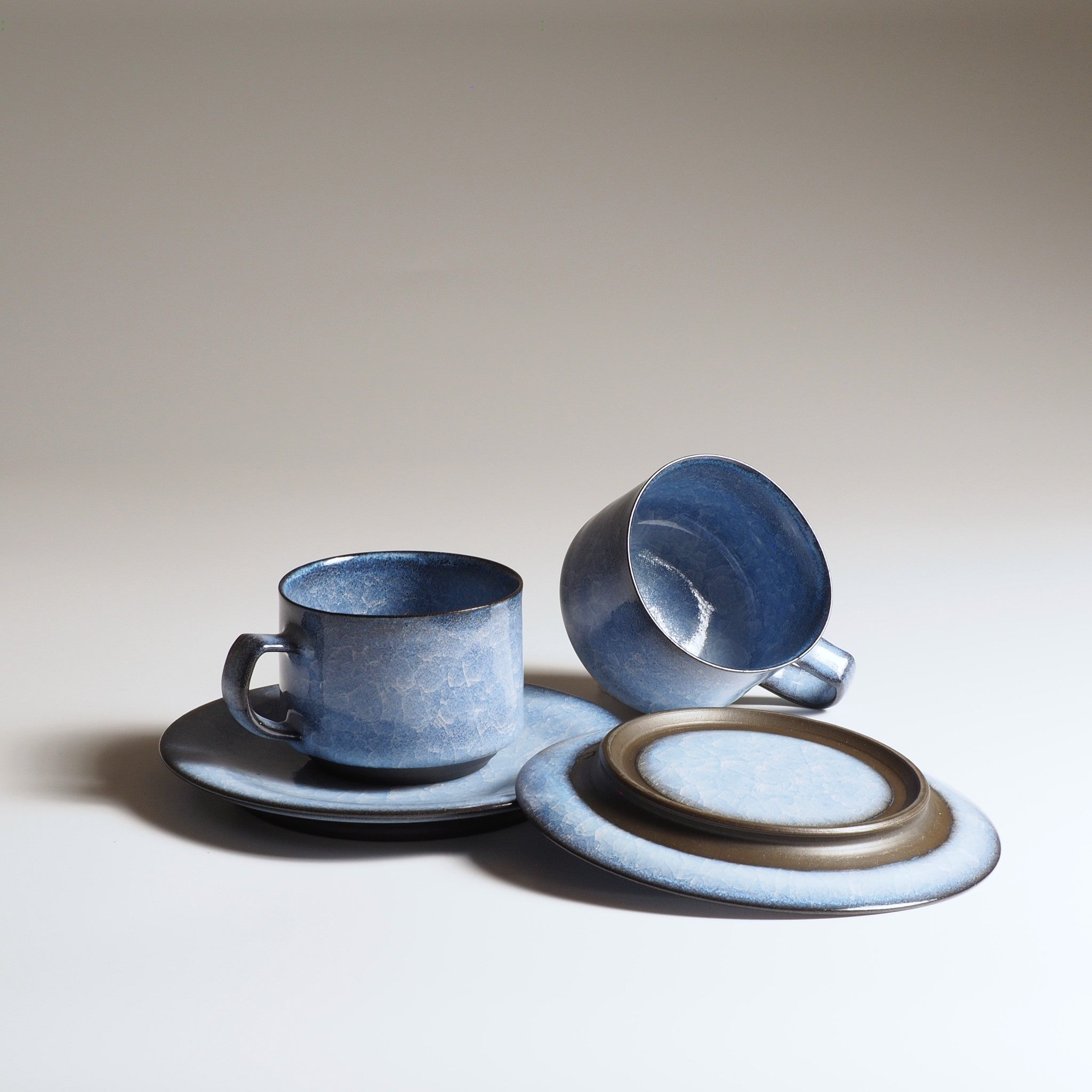 Handcrafted crazing Japanese ceramic coffee cups and saucers background, Tsukushi