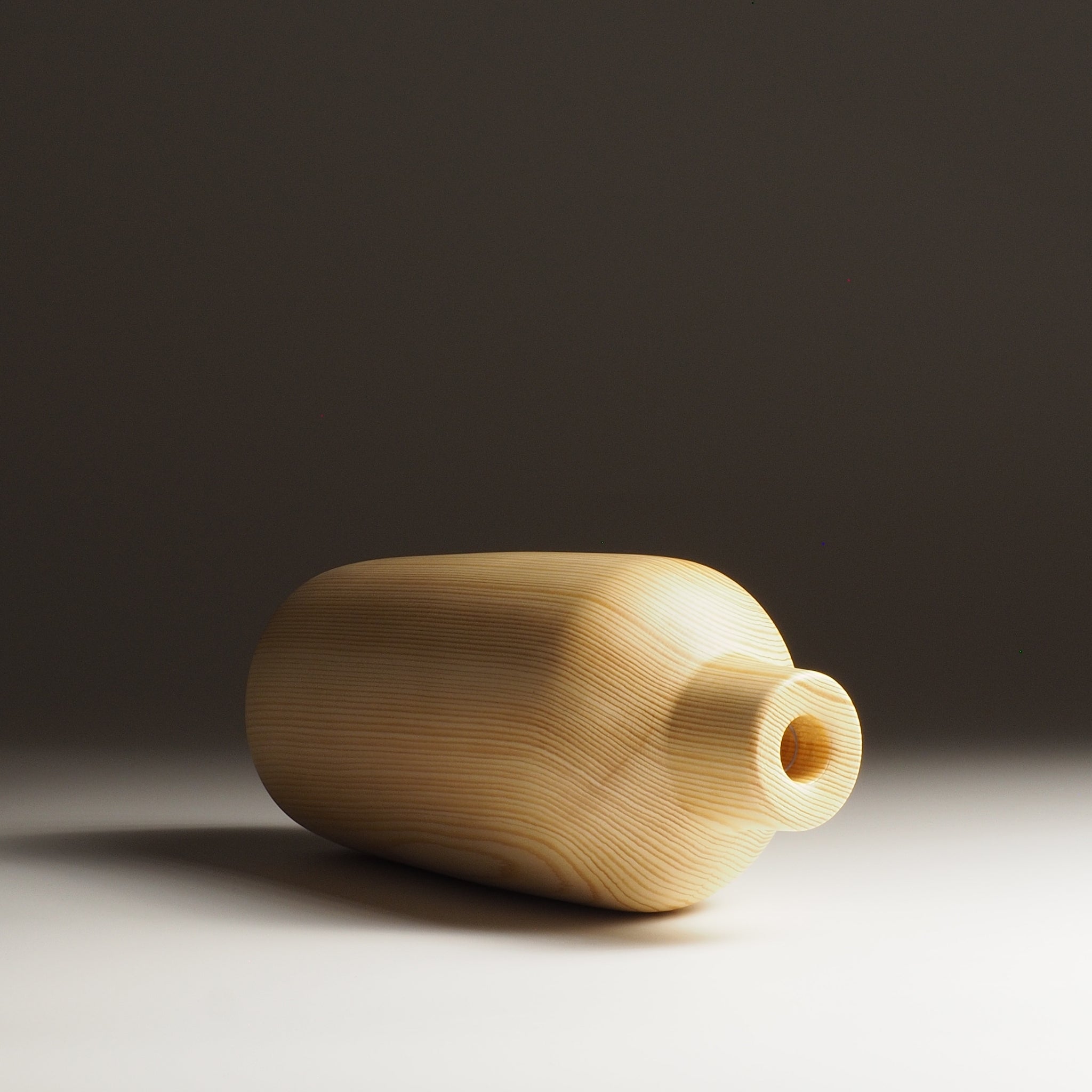 A front view of a Japanese wooden vase on a beige gradient background. Tsukushi